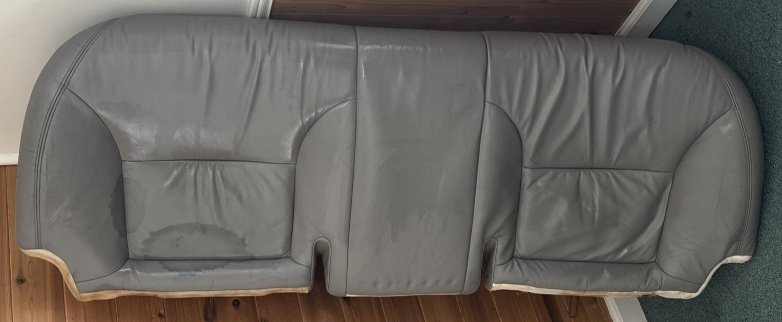 Gray leather car seat on a wooden floor amani auto parts