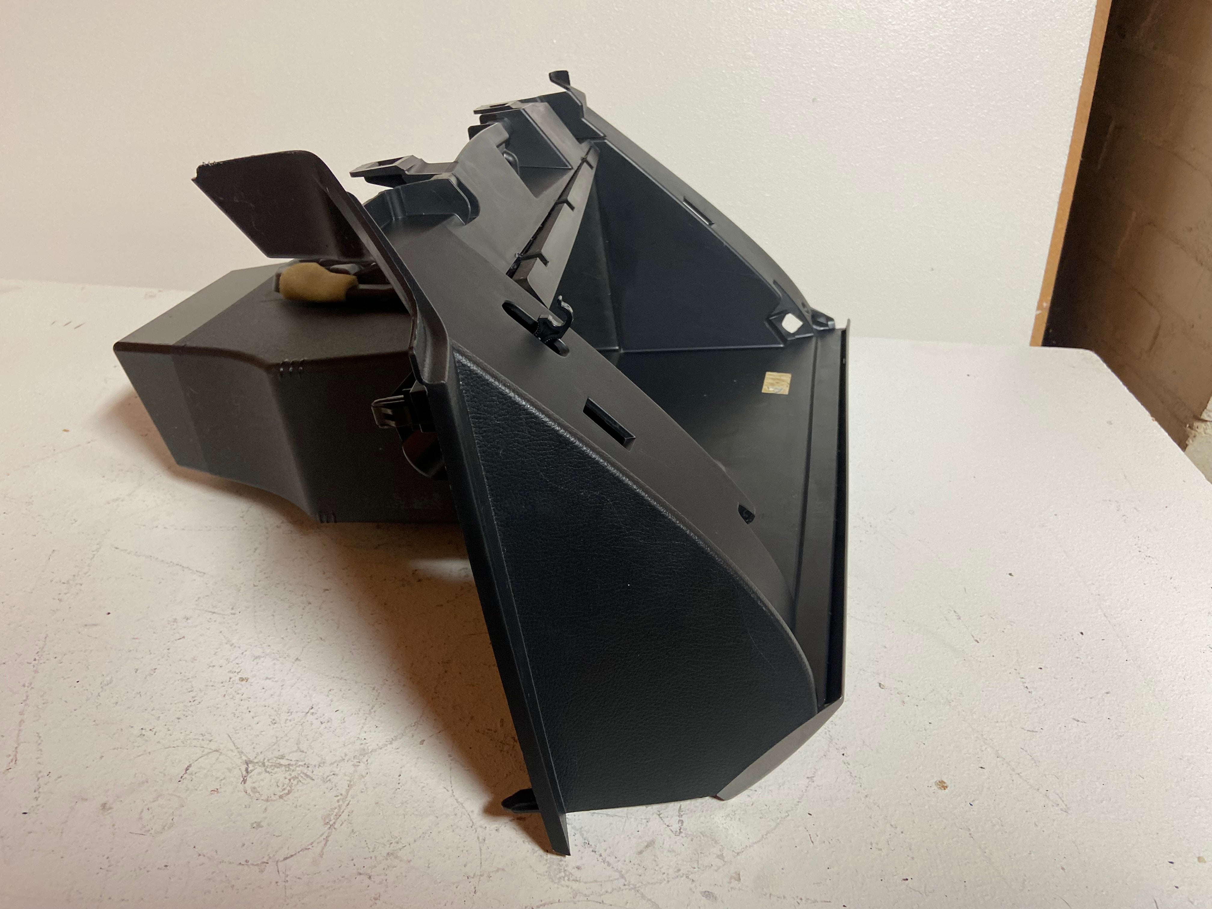 Black dashboard glove box compartment assembly with open faceplate
