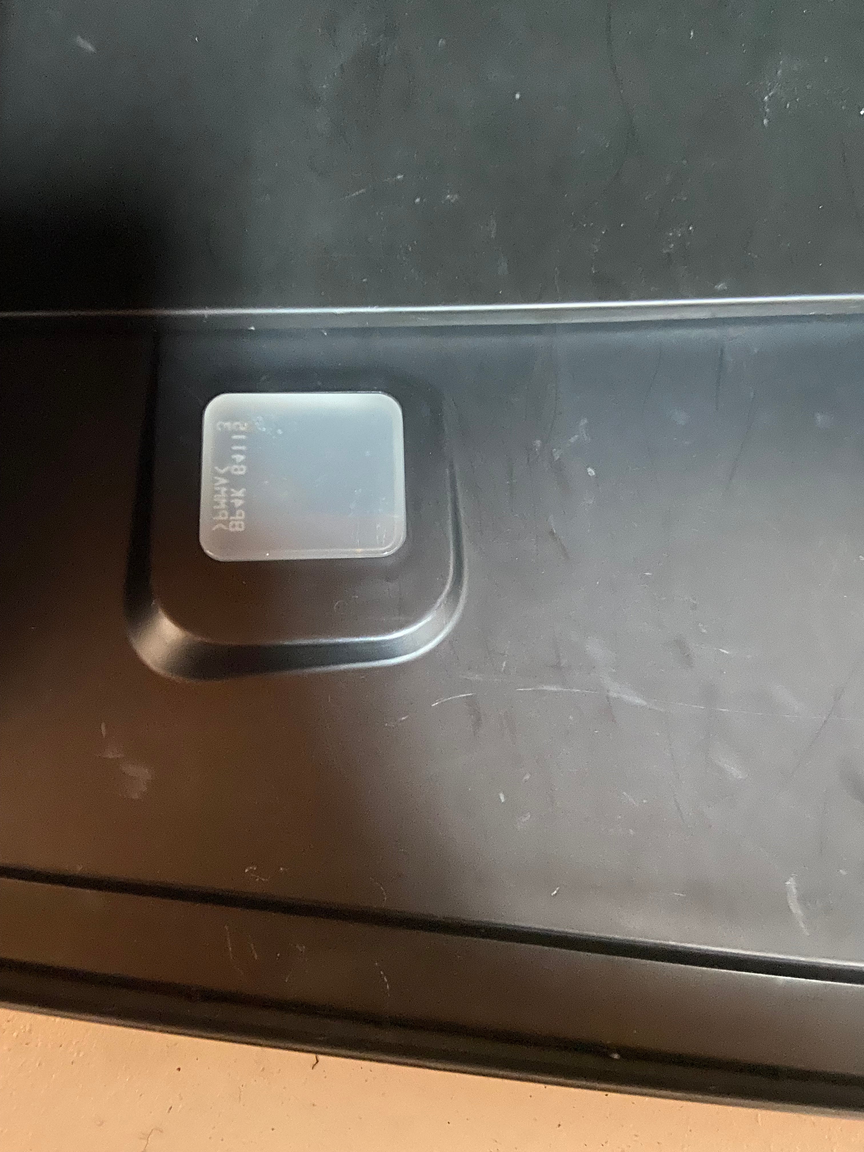 Black dashboard glove box compartment latch area with small access opening
