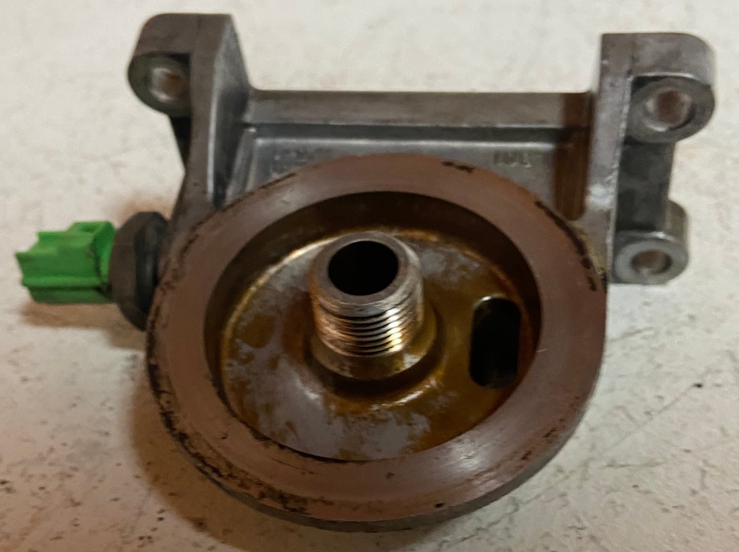 Engine oil filter adapter housing with threaded oil port and green connector