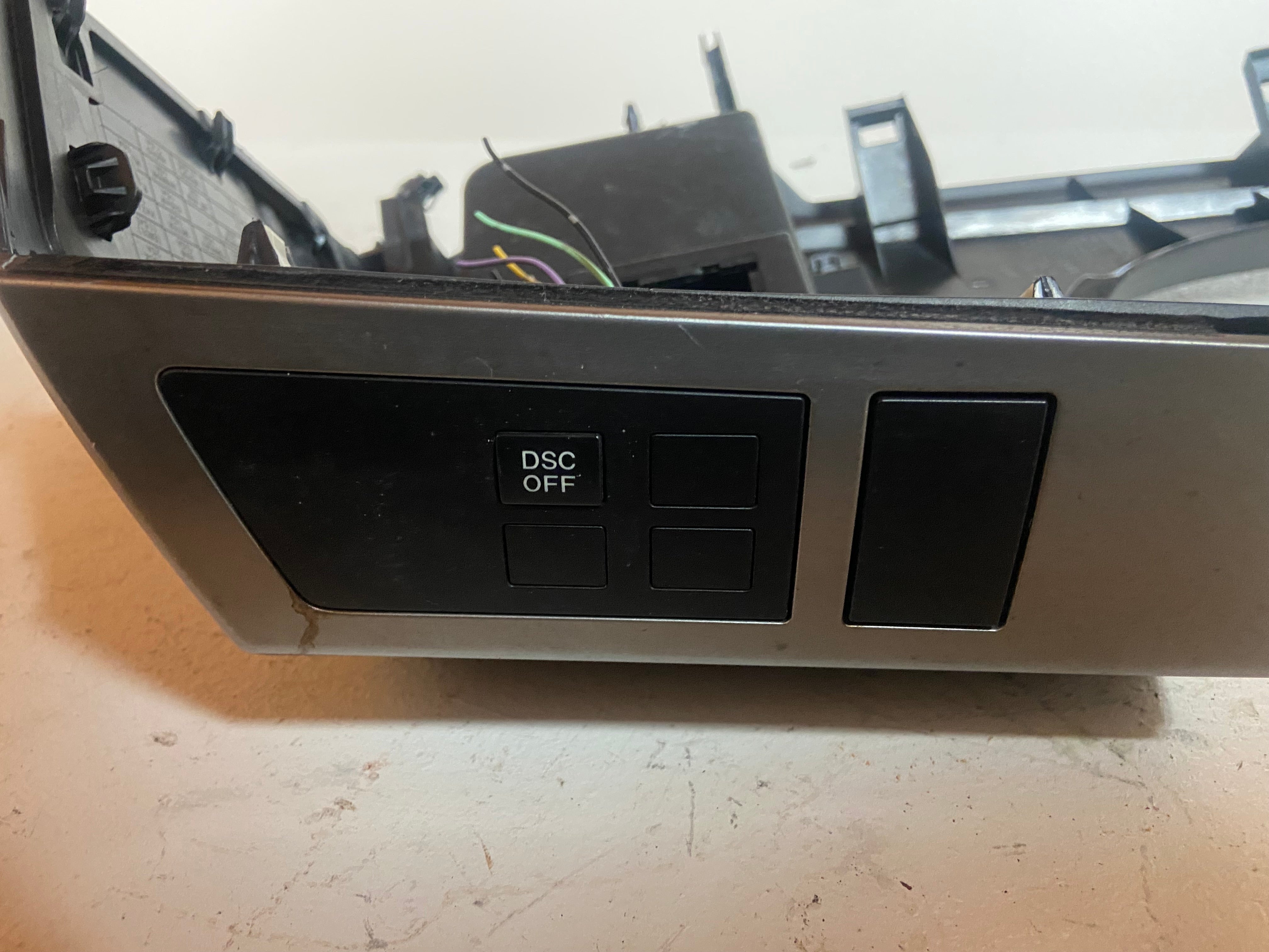 Black dash switch bezel trim with DSC OFF button cutouts