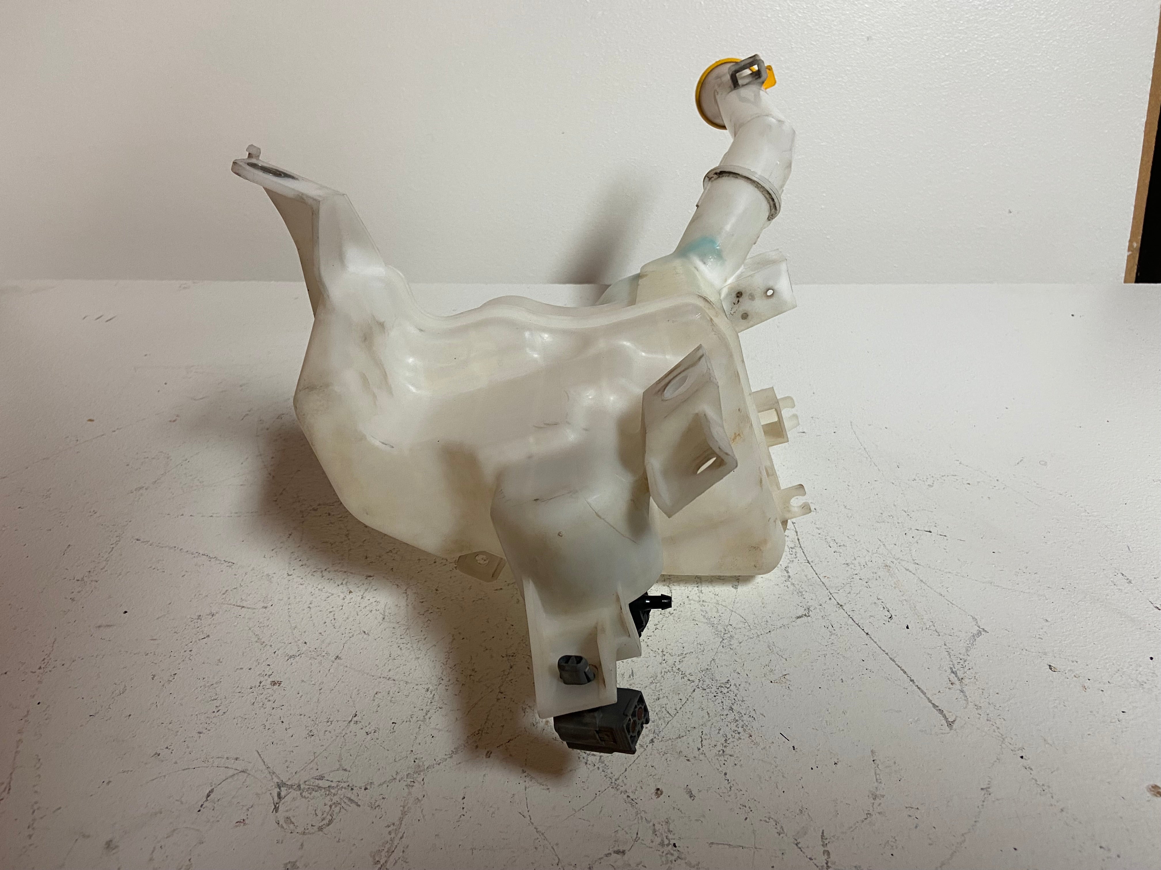 Windshield washer fluid reservoir tank assembly with mounting clips and side connectors