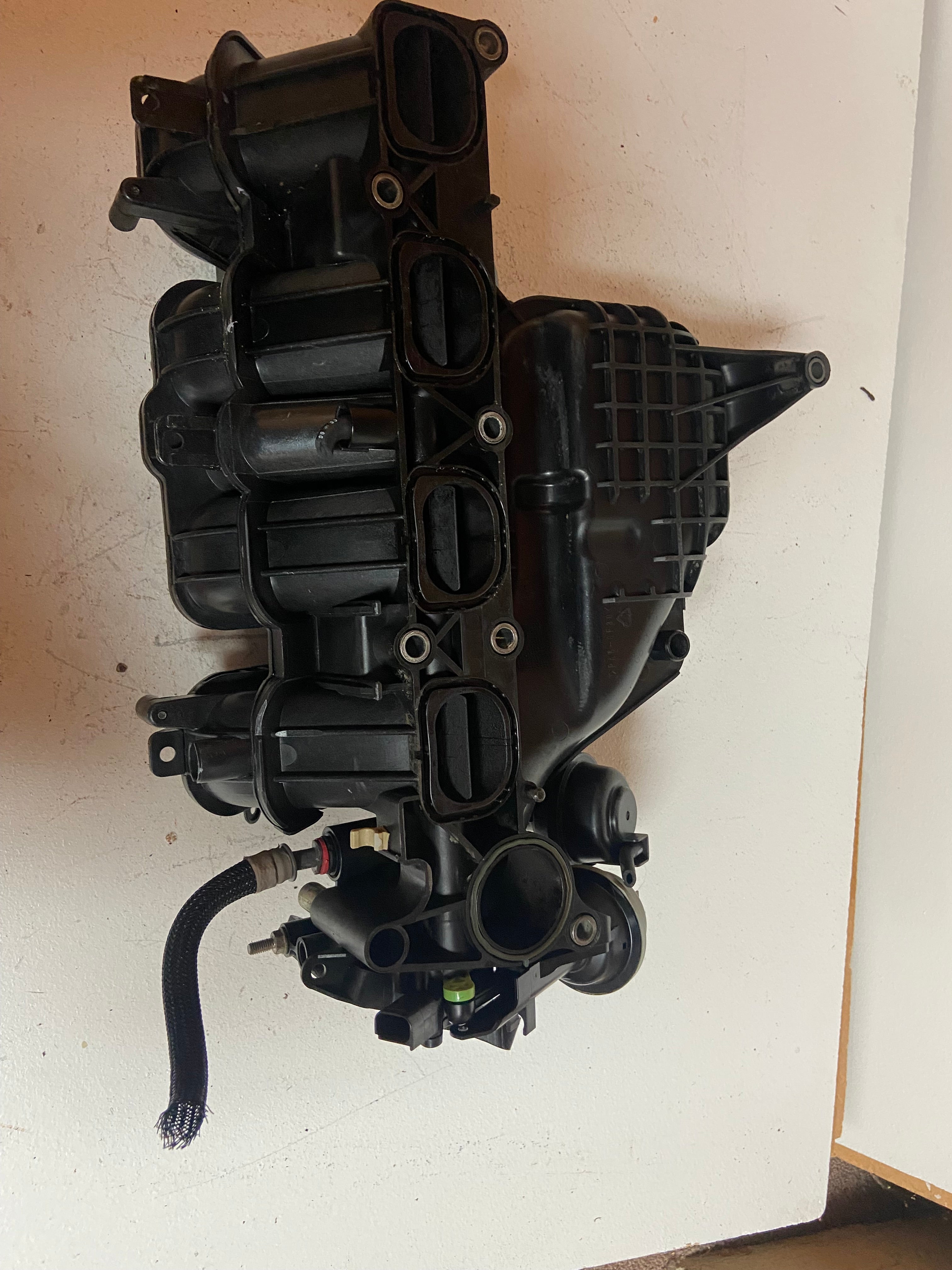 Engine air intake manifold assembly with multiple intake ports and vacuum hoses