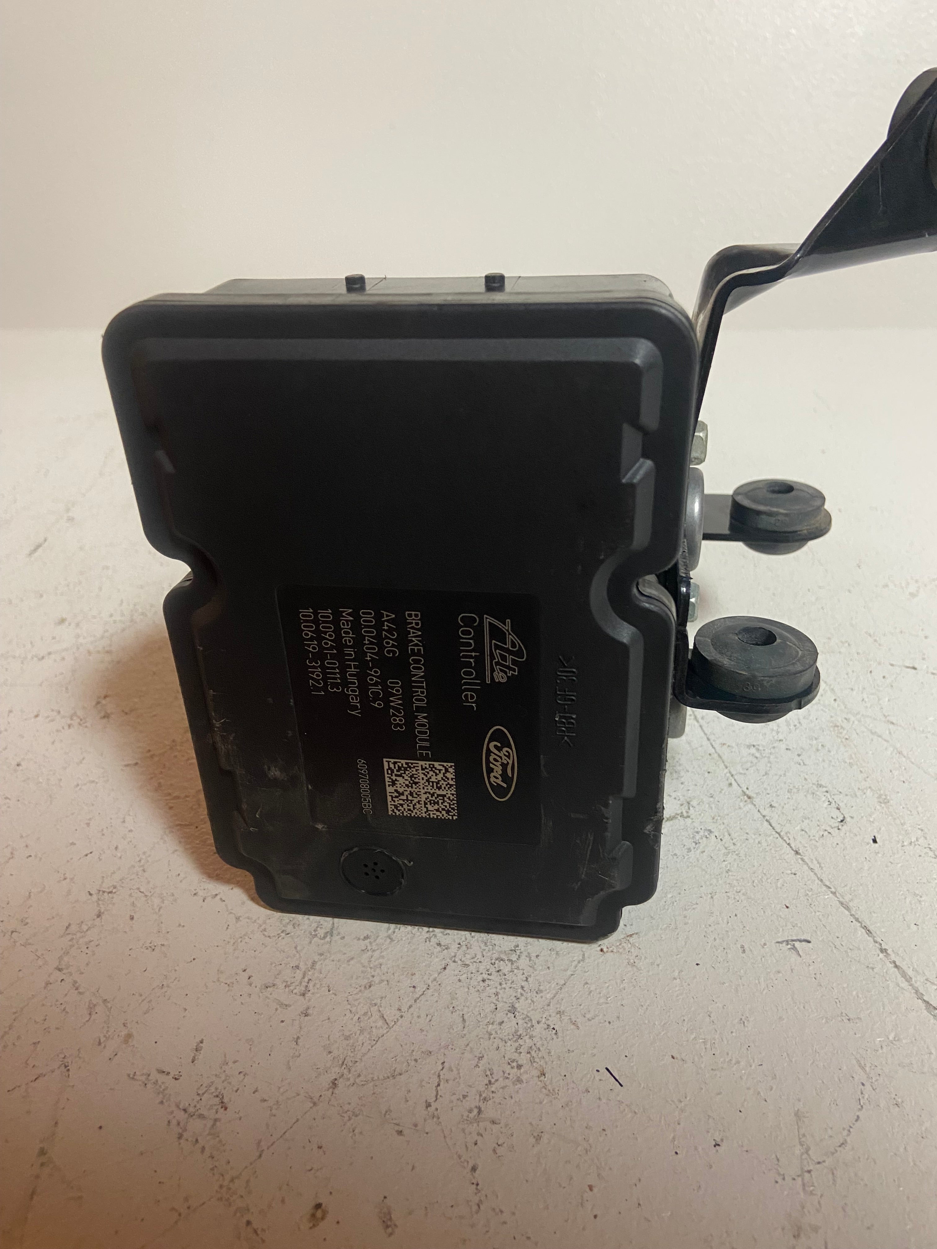 ABS brake pump control module cover with connector ports on dark plastic housing.
