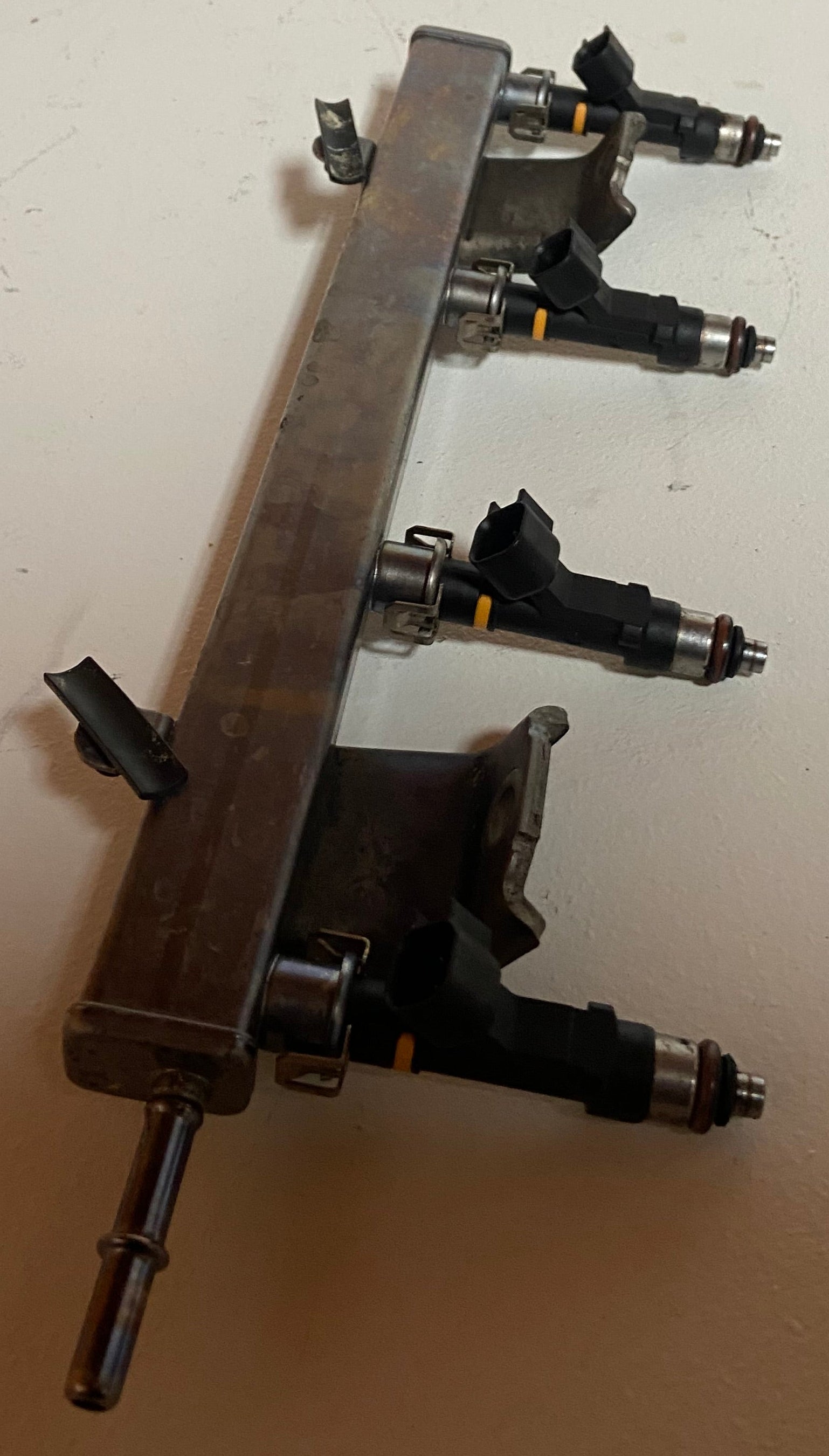 Engine fuel rail assembly with four black injector connectors and support mounts