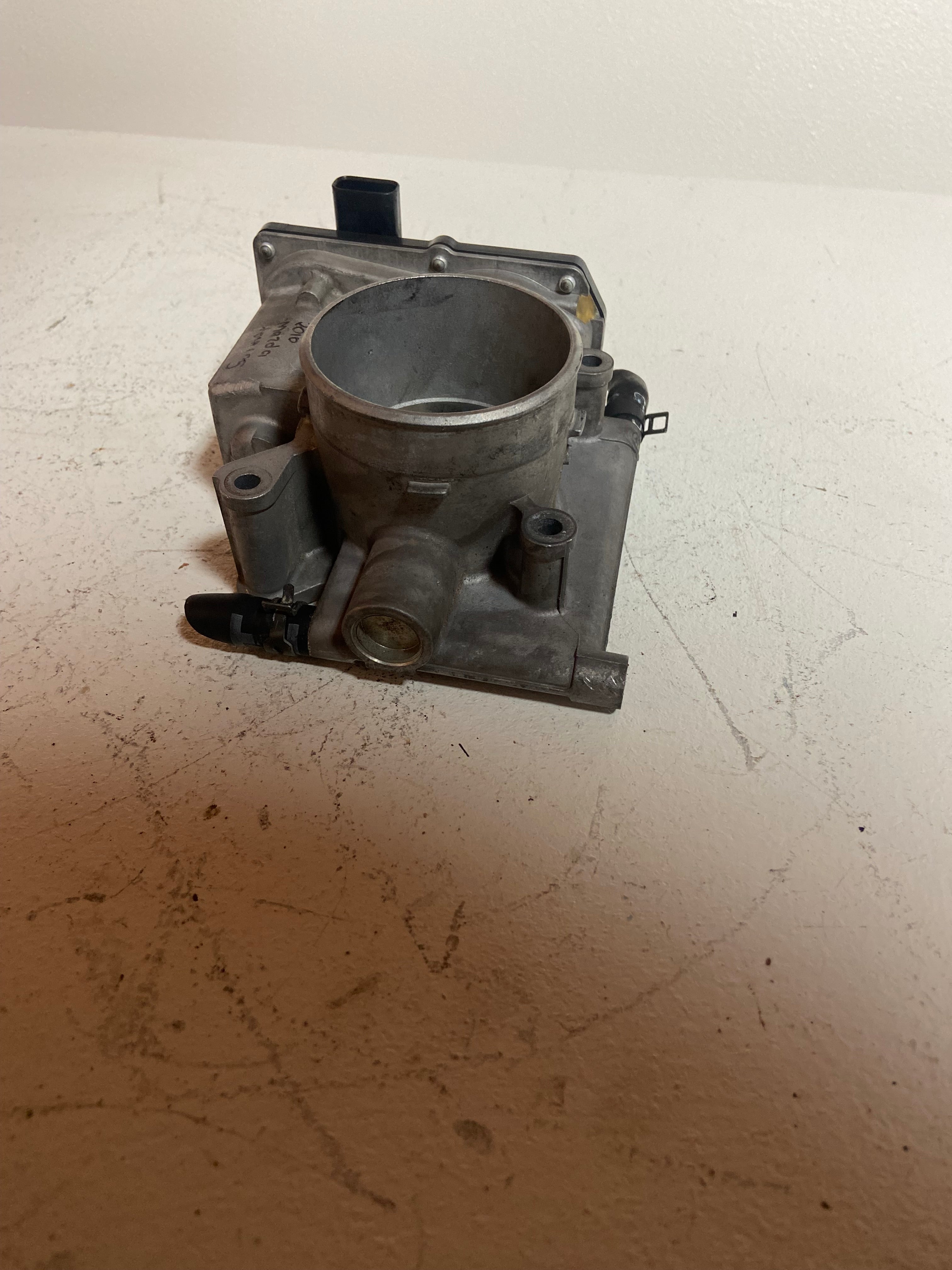 Throttle body housing with round throttle opening and mounting bracket