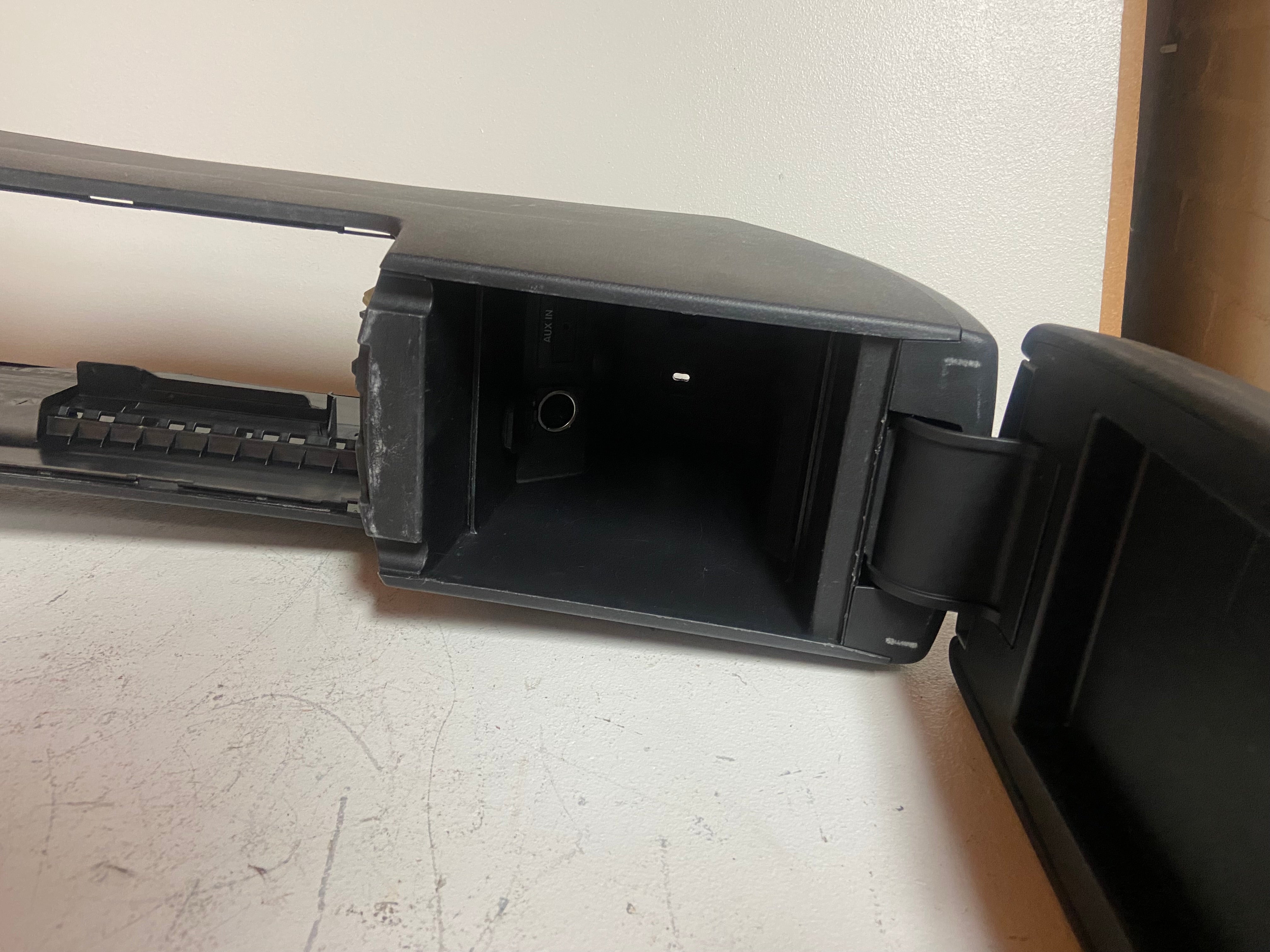 Black console storage compartment with latch and trim edge