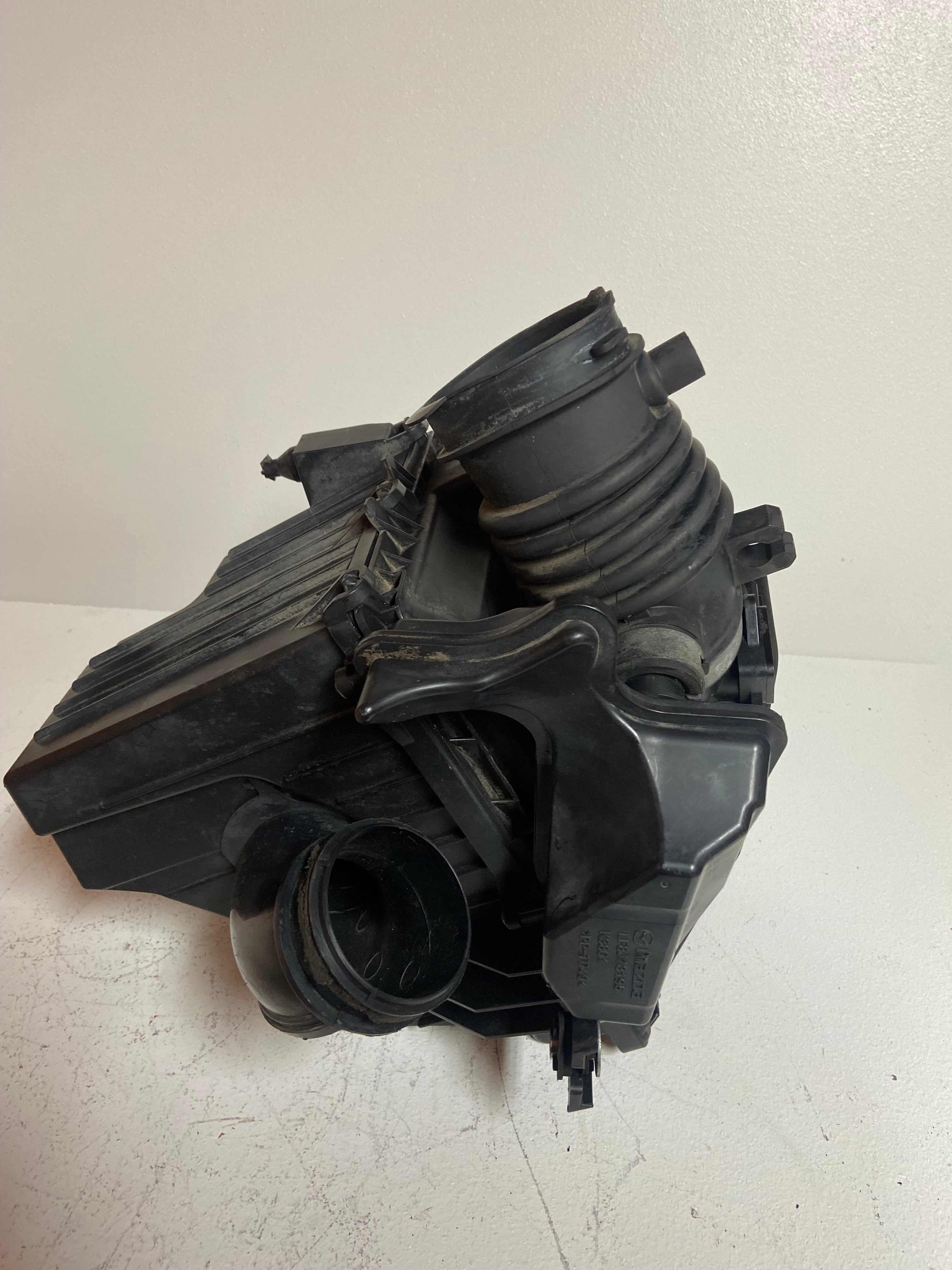 Air intake filter housing with accordion intake boot and attached duct opening