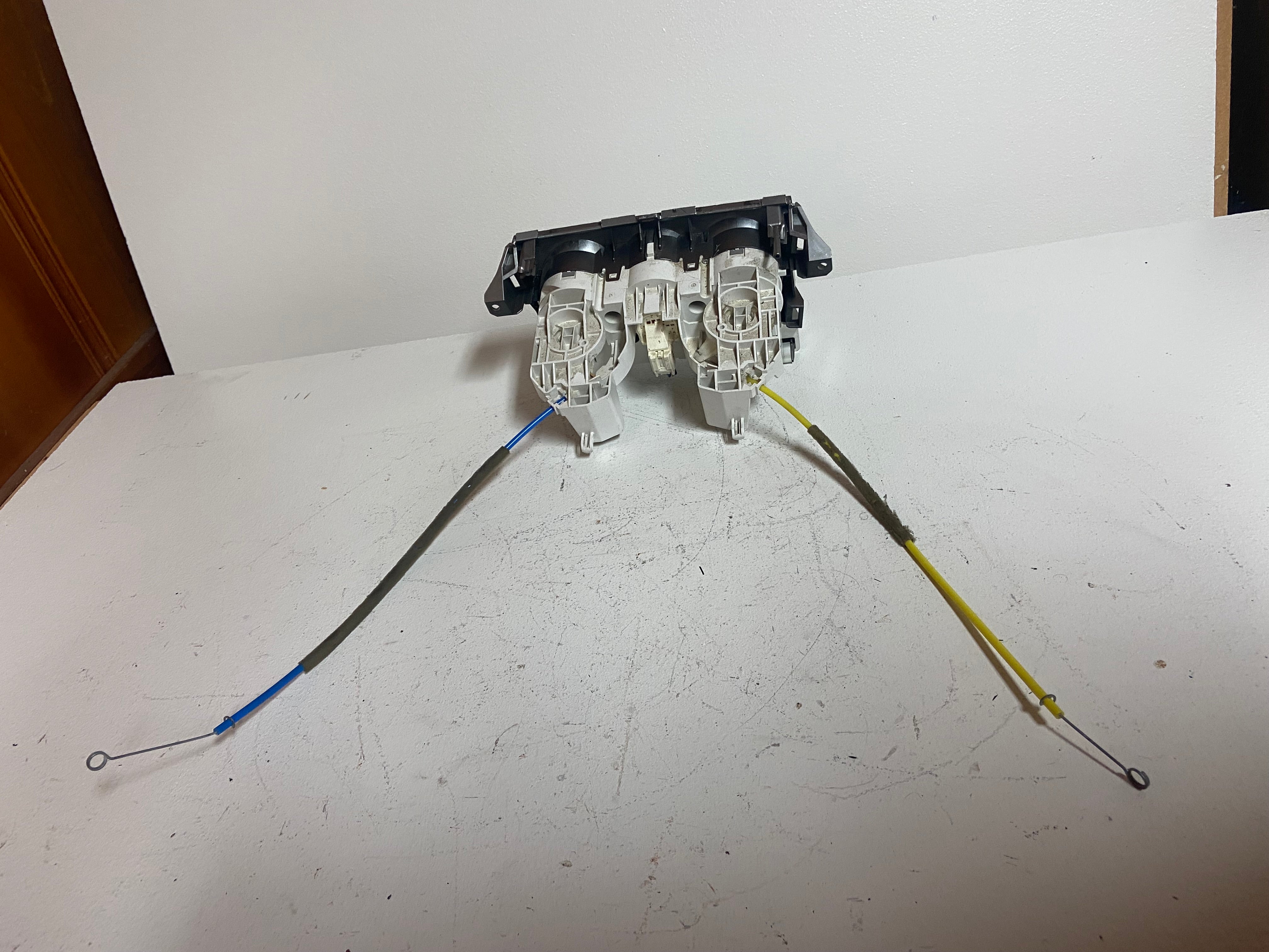 Climate control actuator unit with two white motor housings and colored cable leads