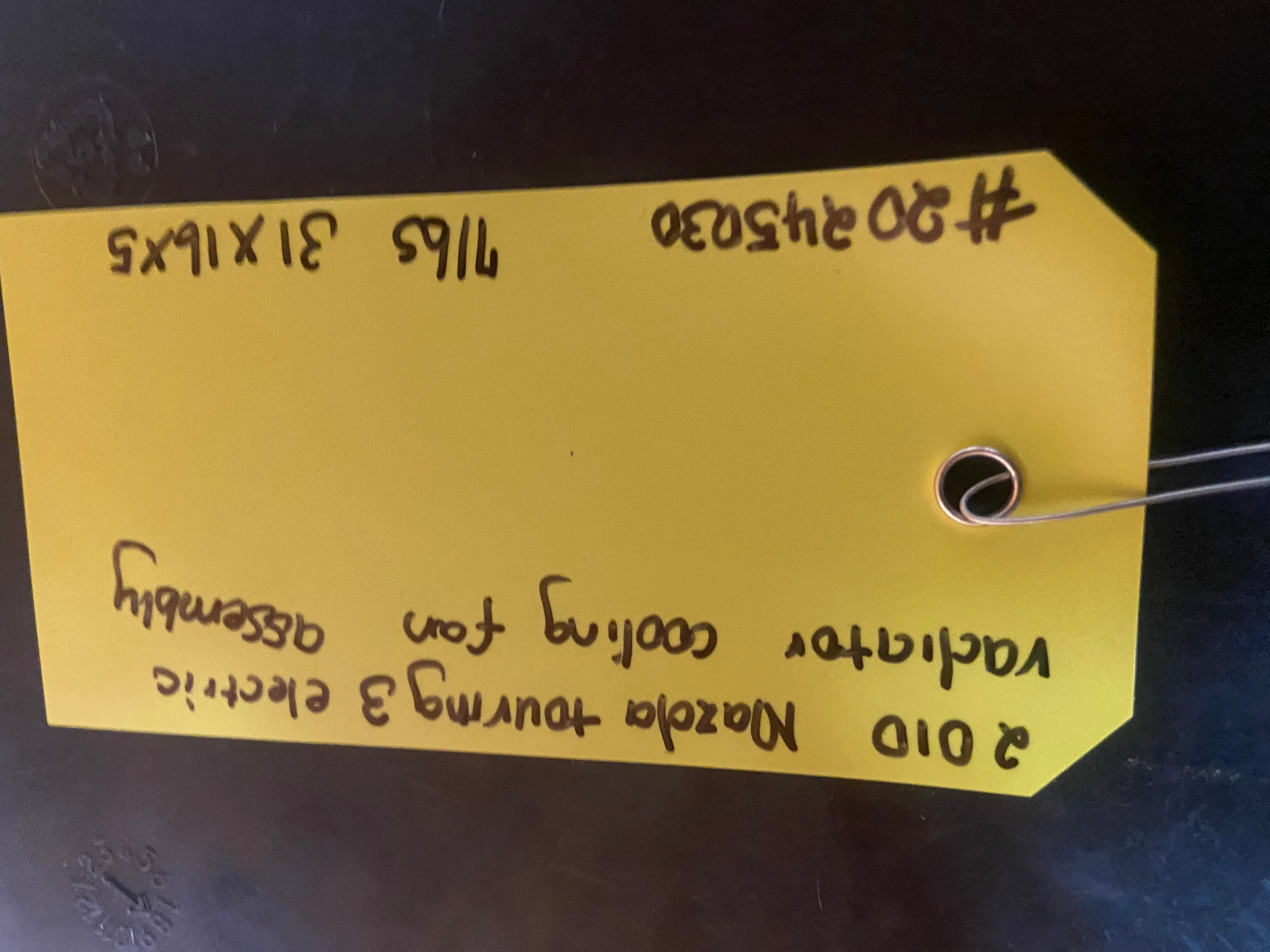 Electric radiator cooling fan assembly with yellow parts tag and handwritten notes