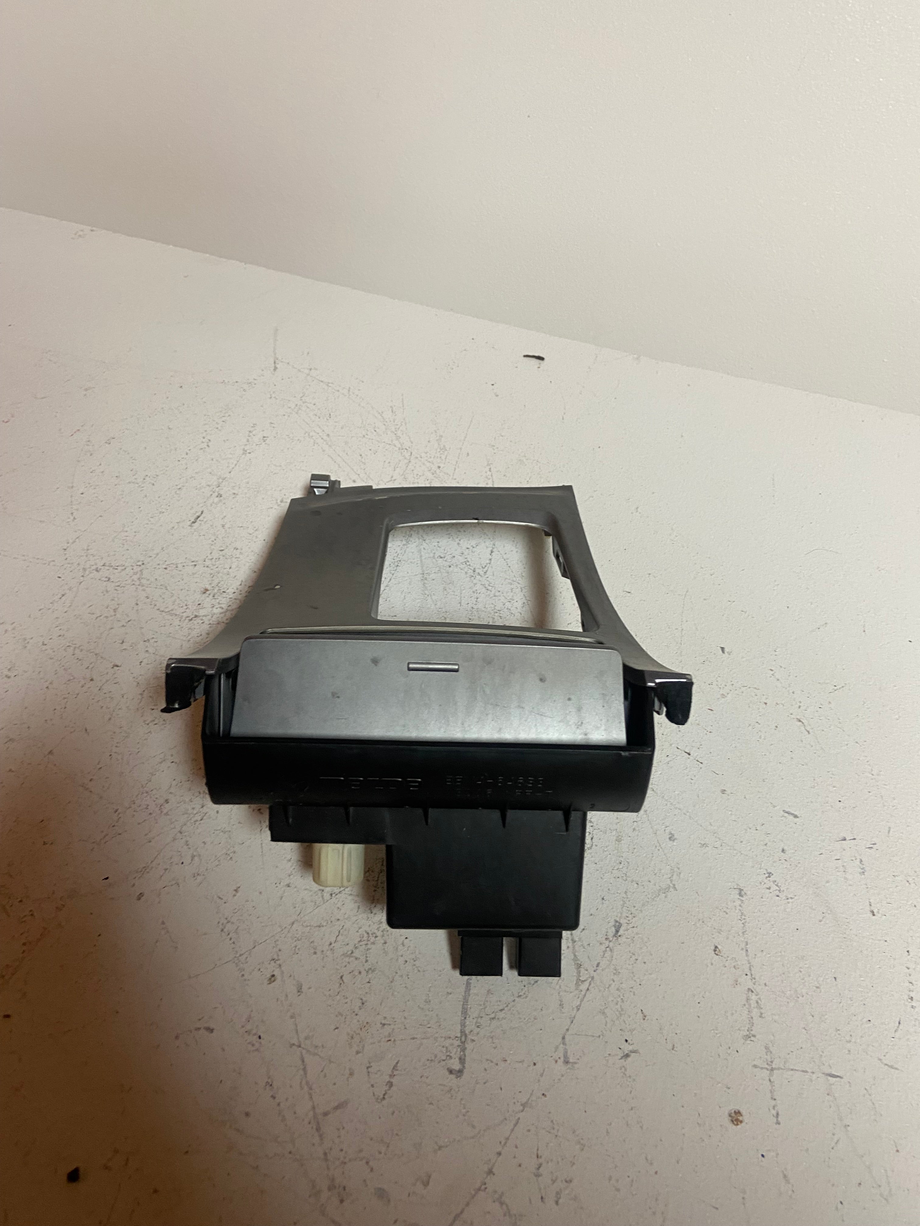 Shifter trim bezel with gray surround and black back housing, rectangular opening