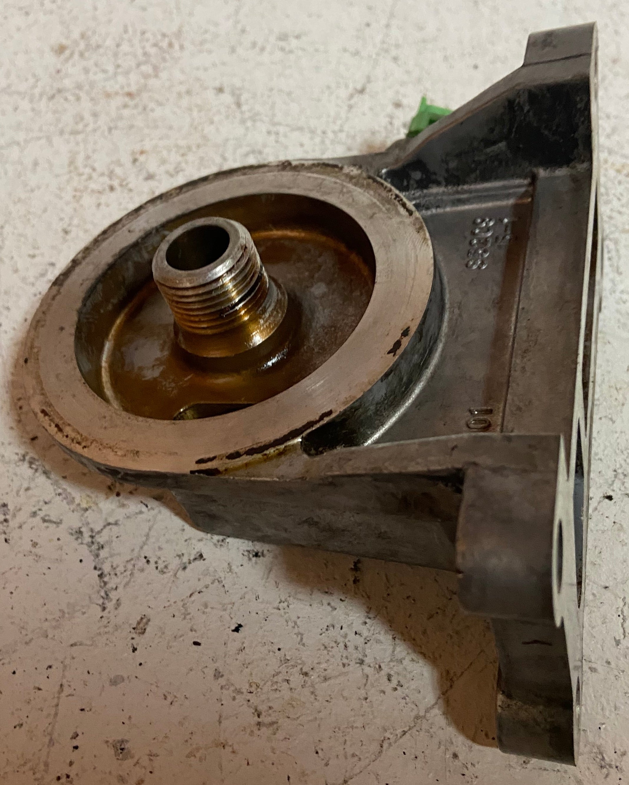 Engine oil filter adapter base with threaded outlet and circular mounting opening