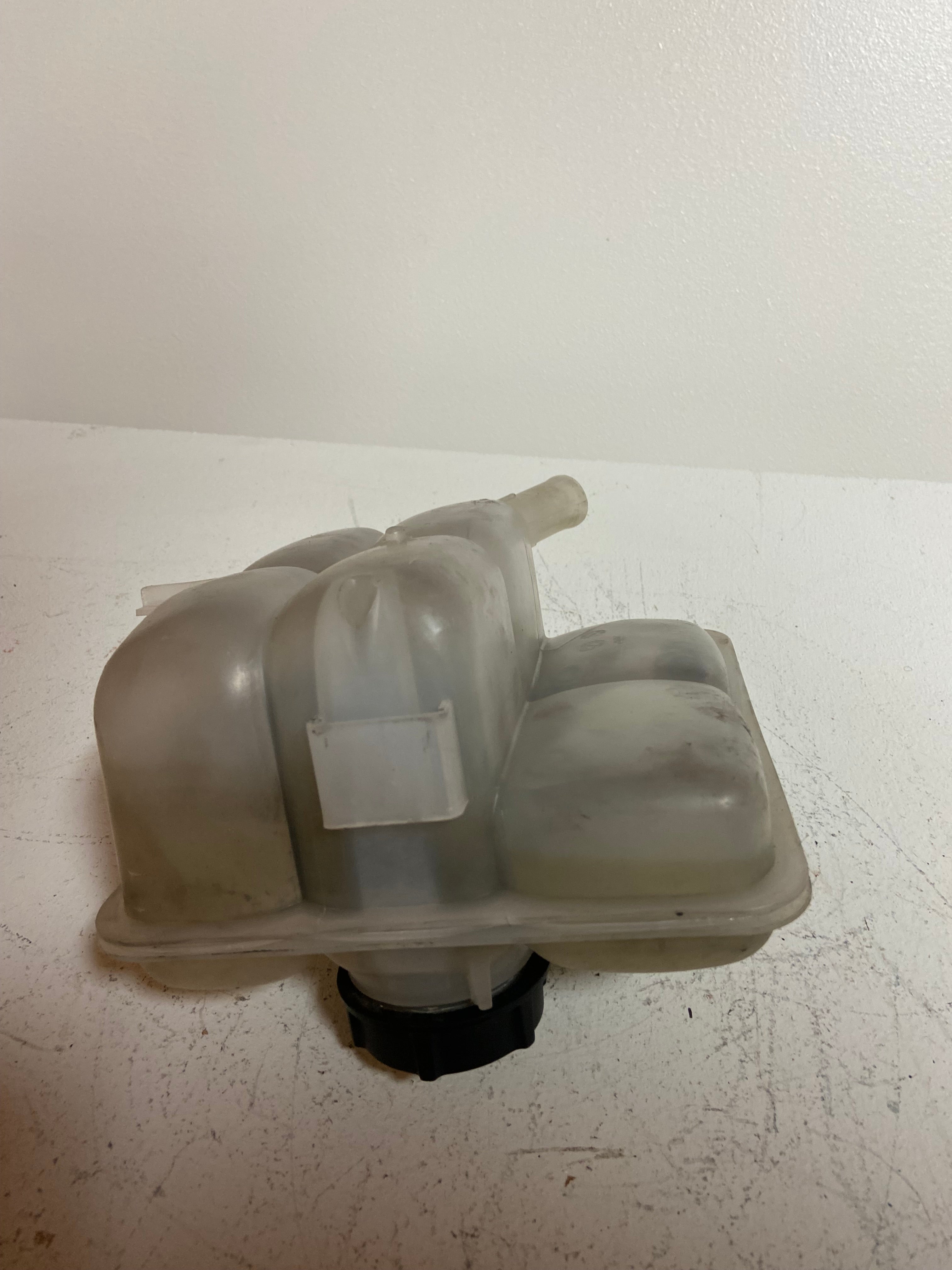 Engine coolant reservoir tank with molded contours and two side hose fittings