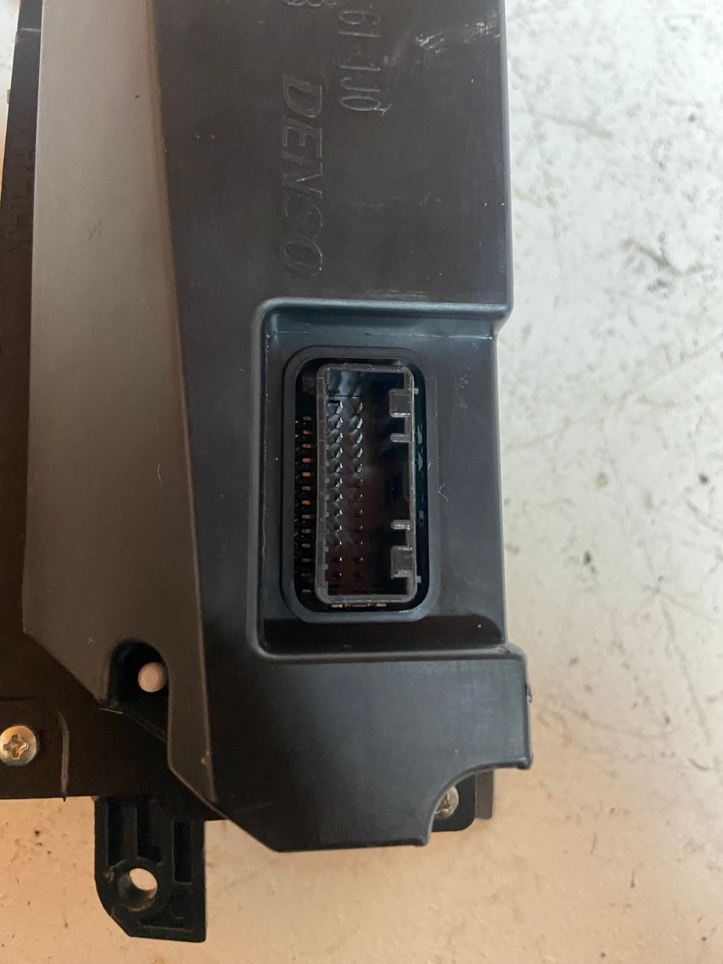 Black display screen module with wiring connector port and metal mounting tabs