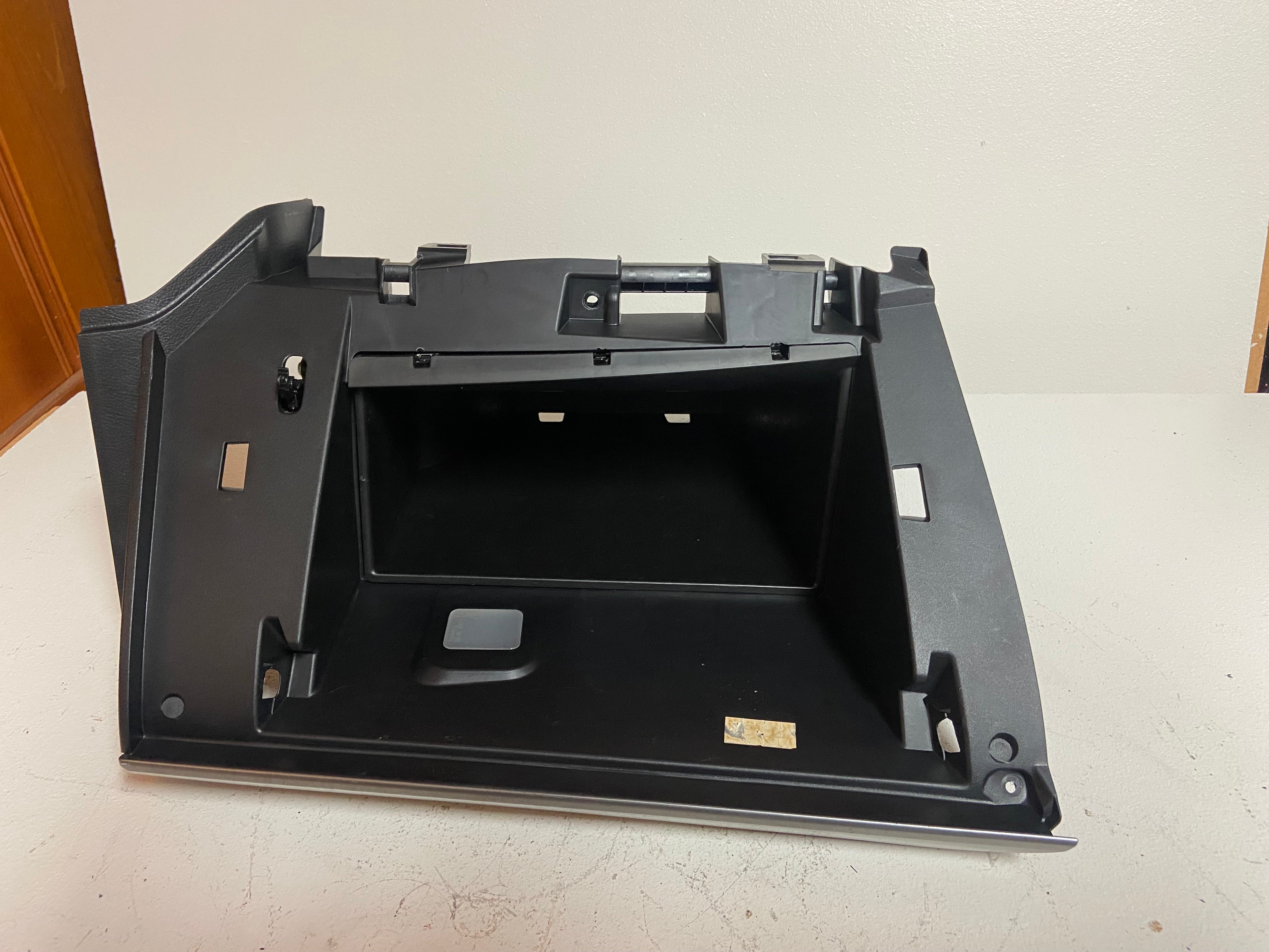 Black glove box compartment base tray with mounting holes and recessed handle