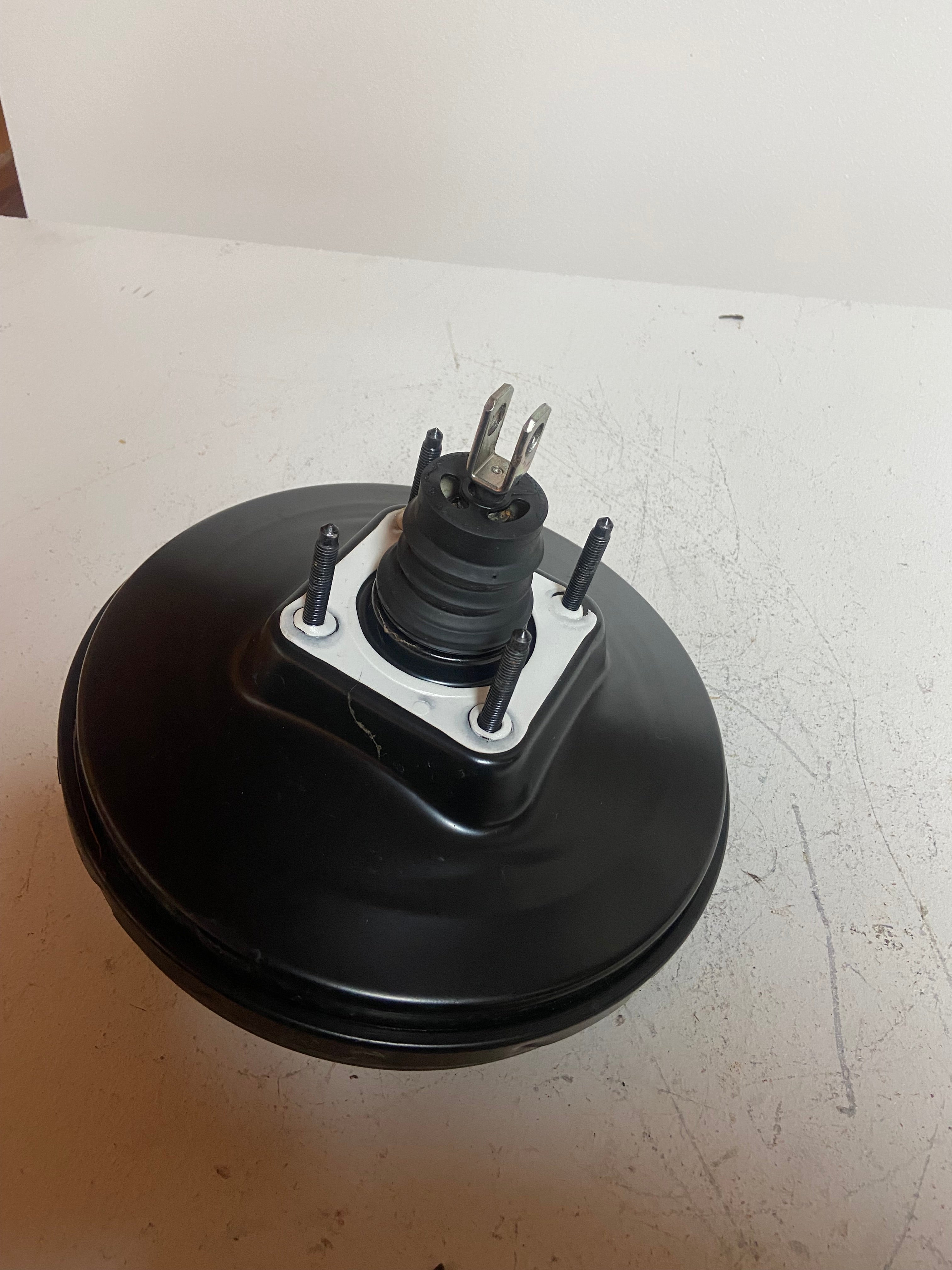 Black power brake booster with three mounting studs and electrical connector