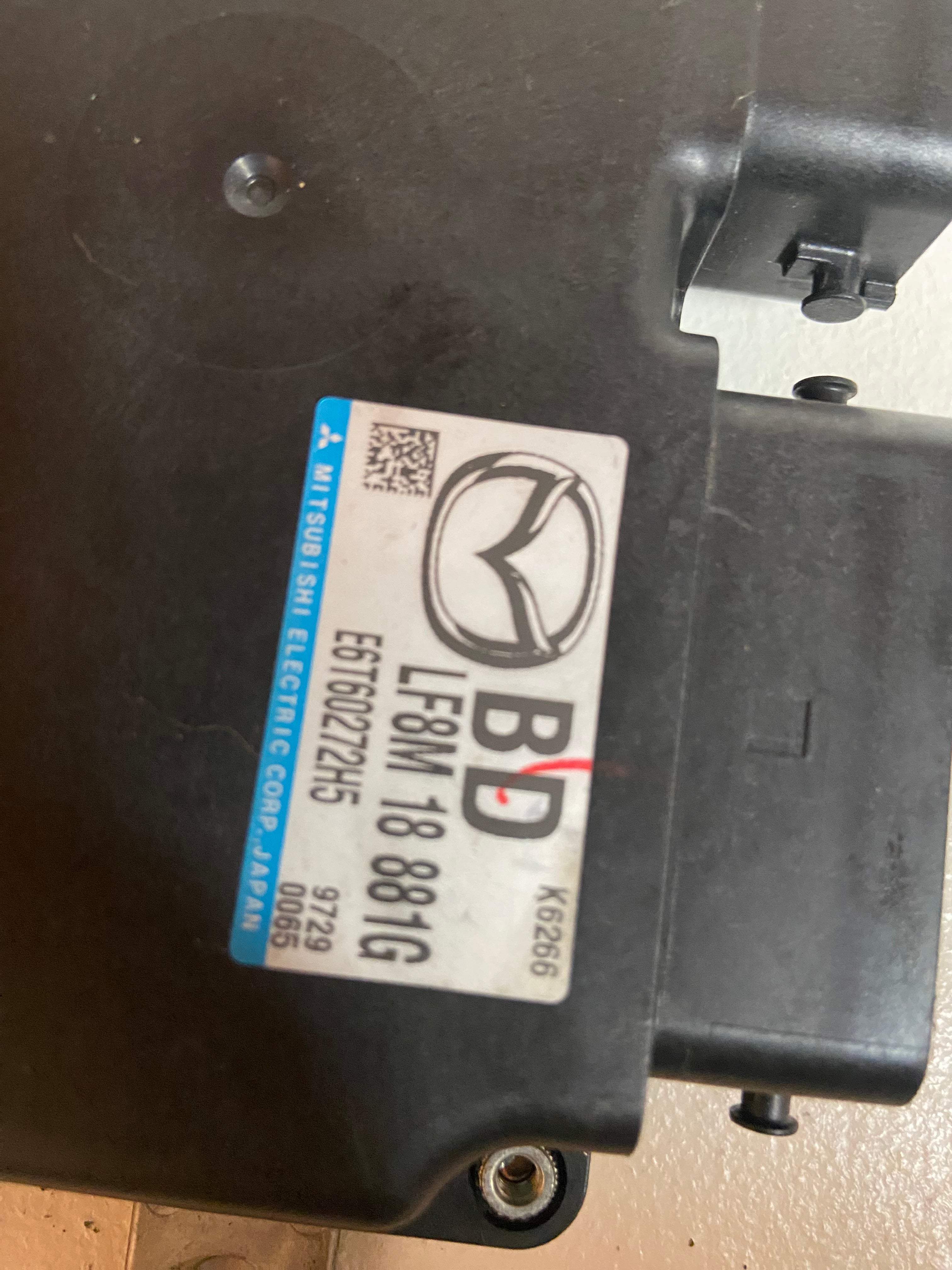 Black engine control unit with product label and gray housing bracket