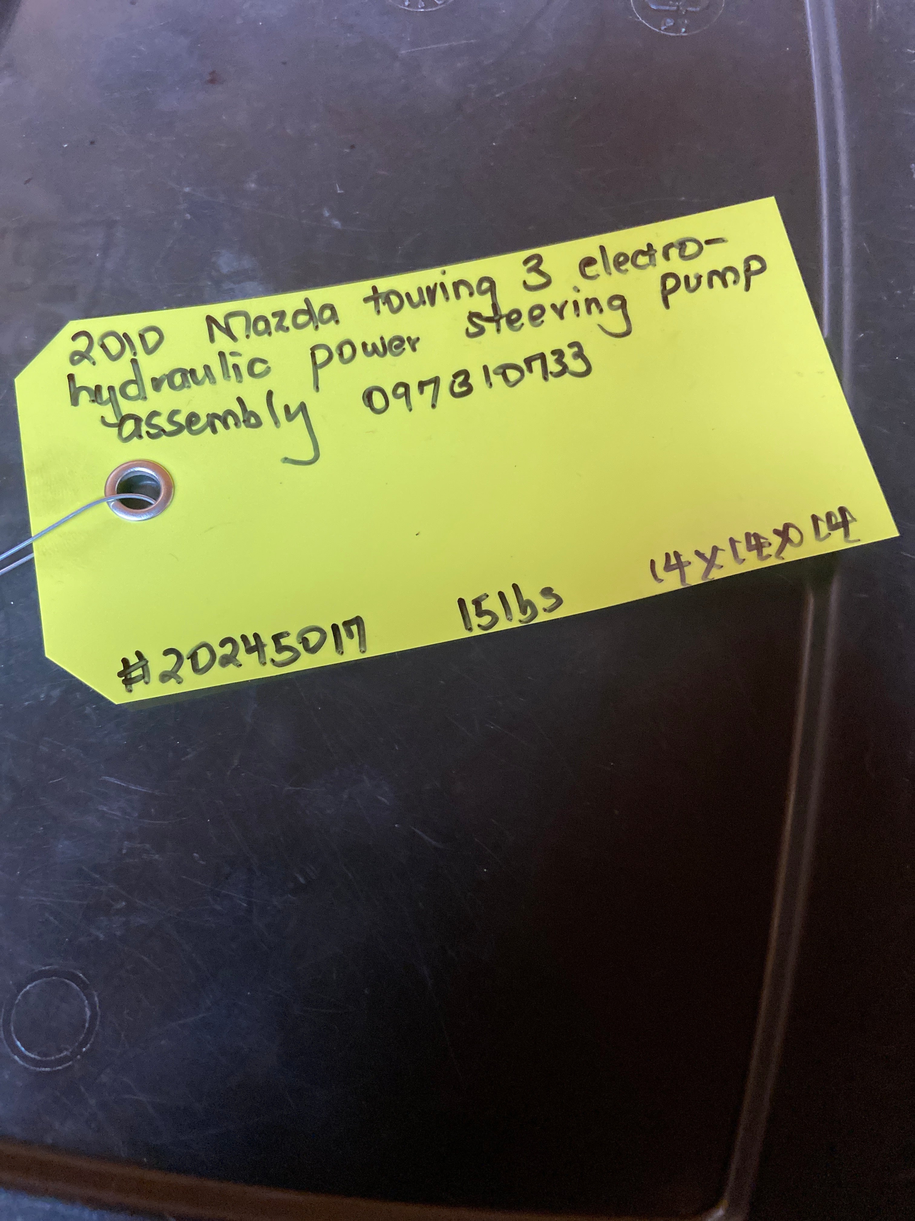 Power steering pump assembly with yellow handwritten inventory tag