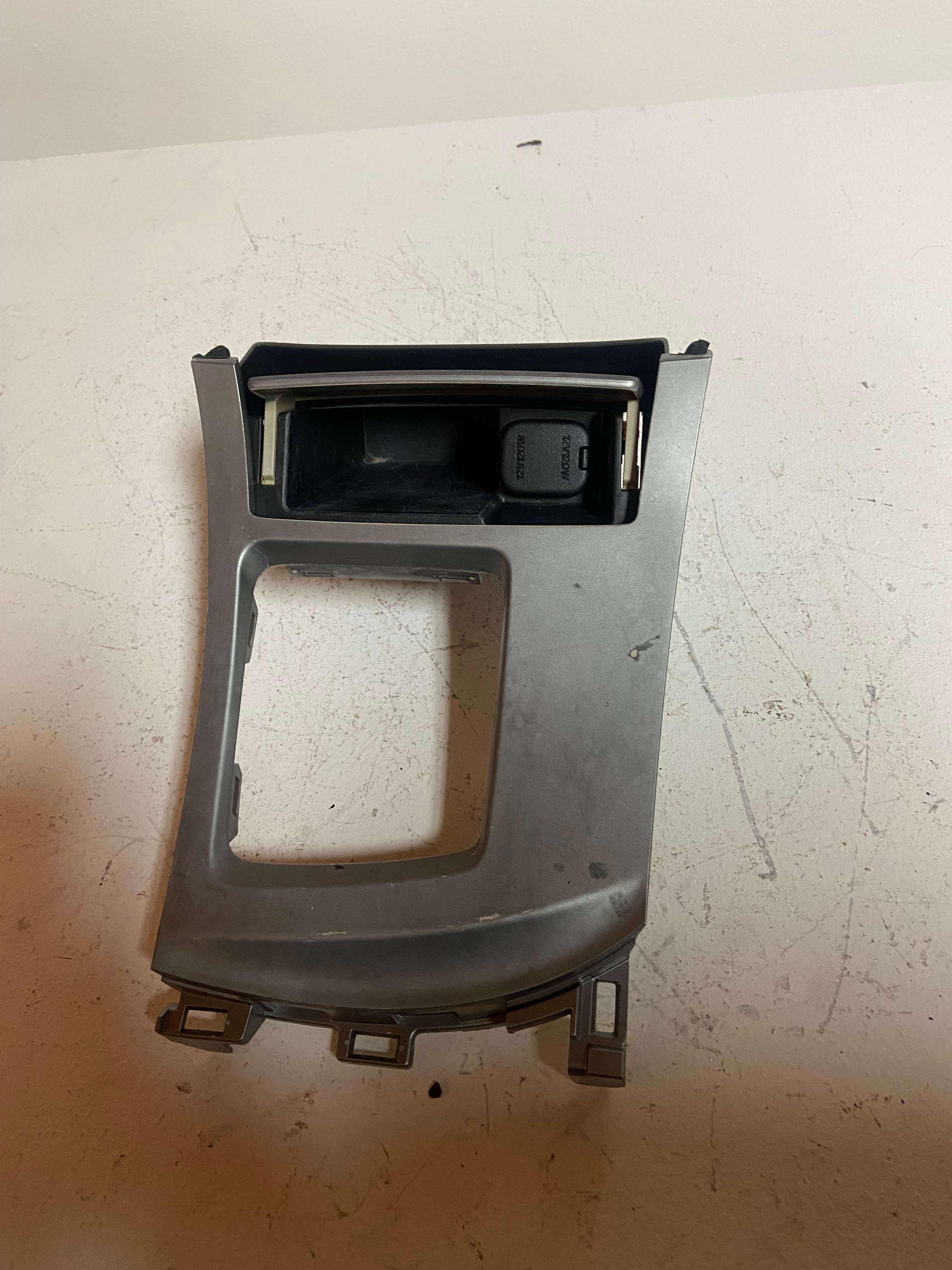 Gray center console trim bezel with black cavity and small switch panel