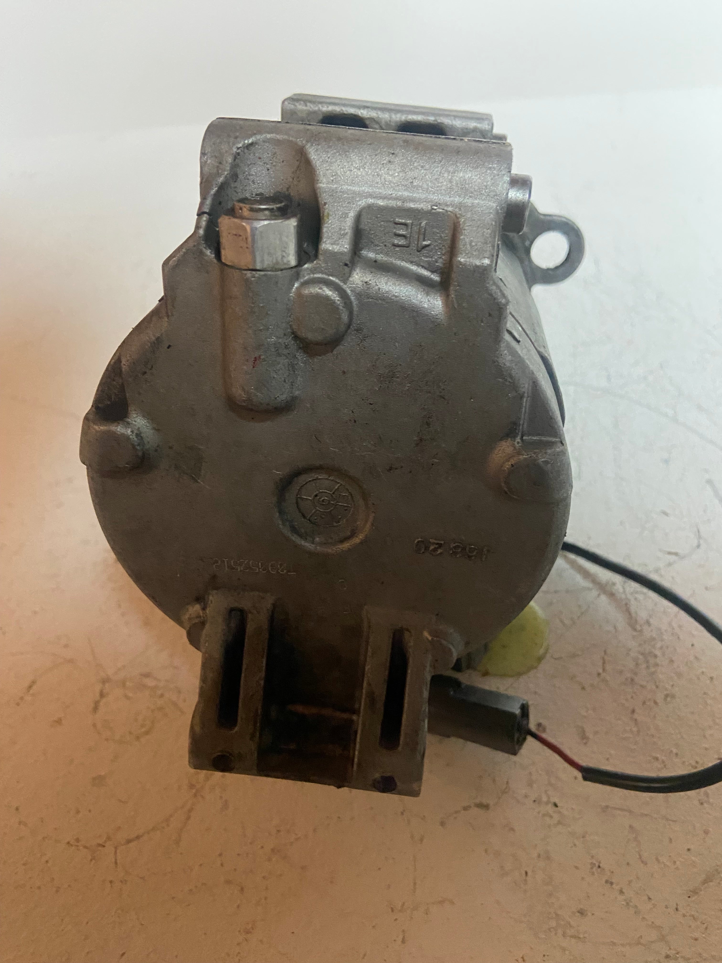 Used A/C compressor with pulley, electrical connectors, and mounting brackets