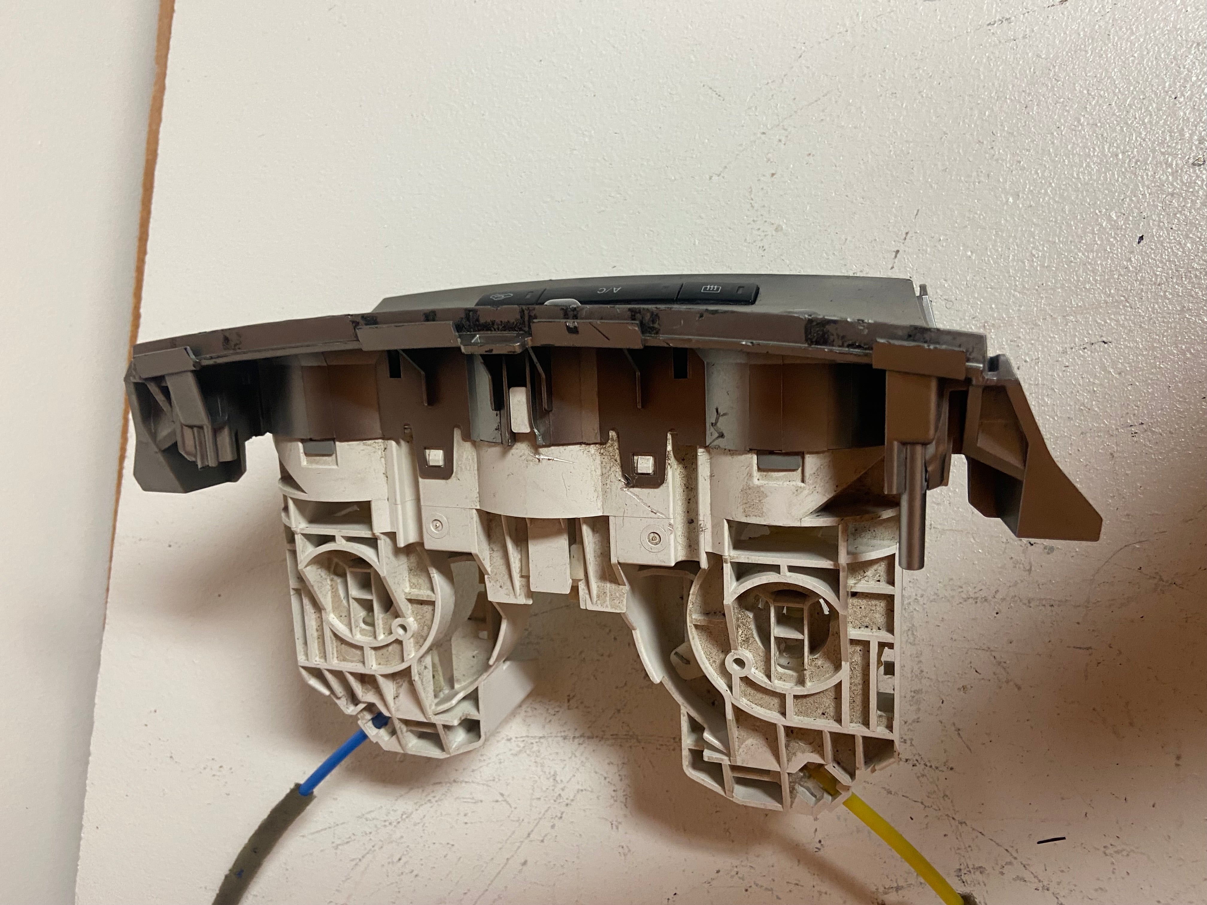 Plastic actuator frame inside view with molded cavities and attached cable ends