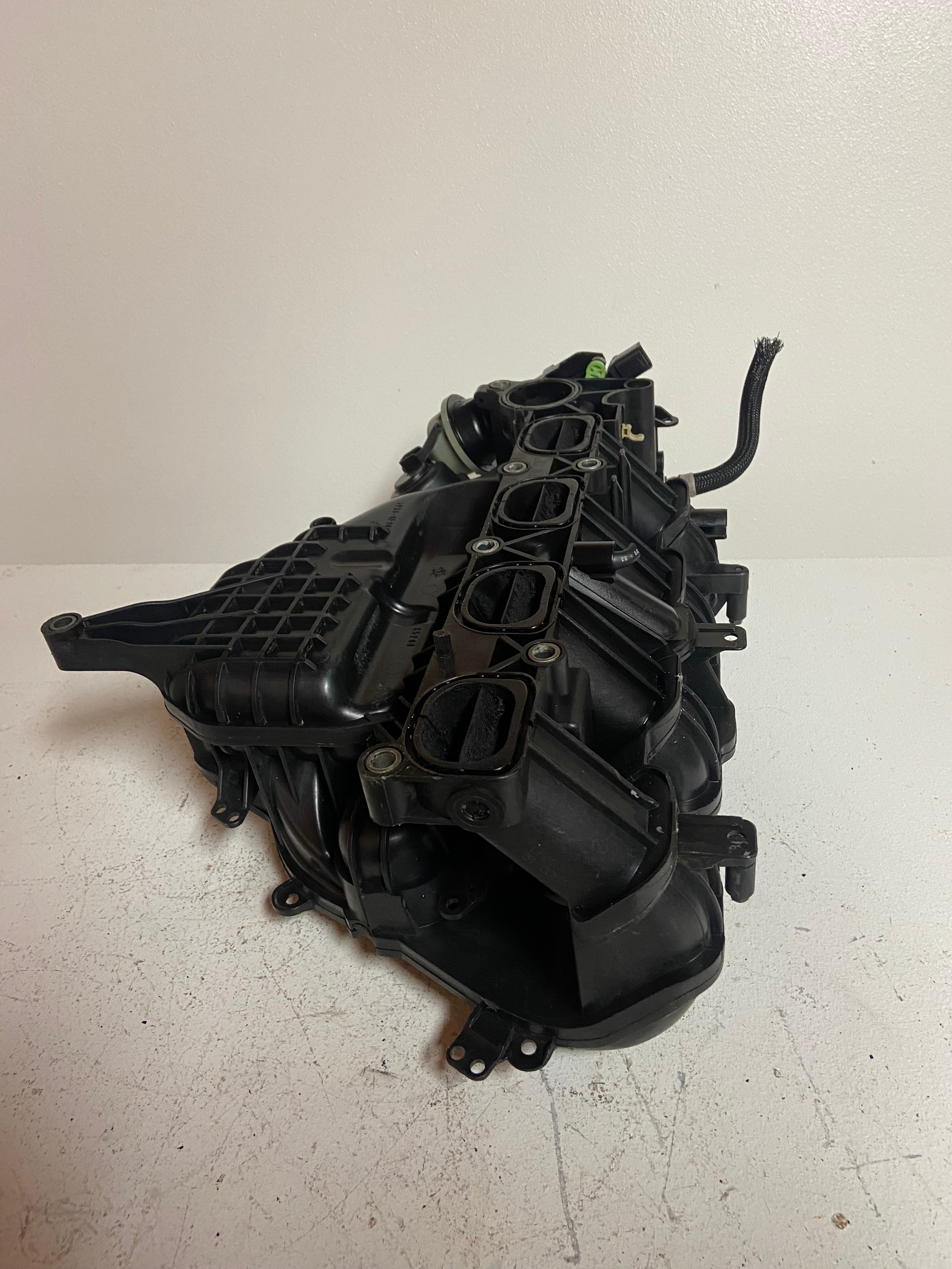 Engine air intake manifold underside with vacuum lines and mounting hardware