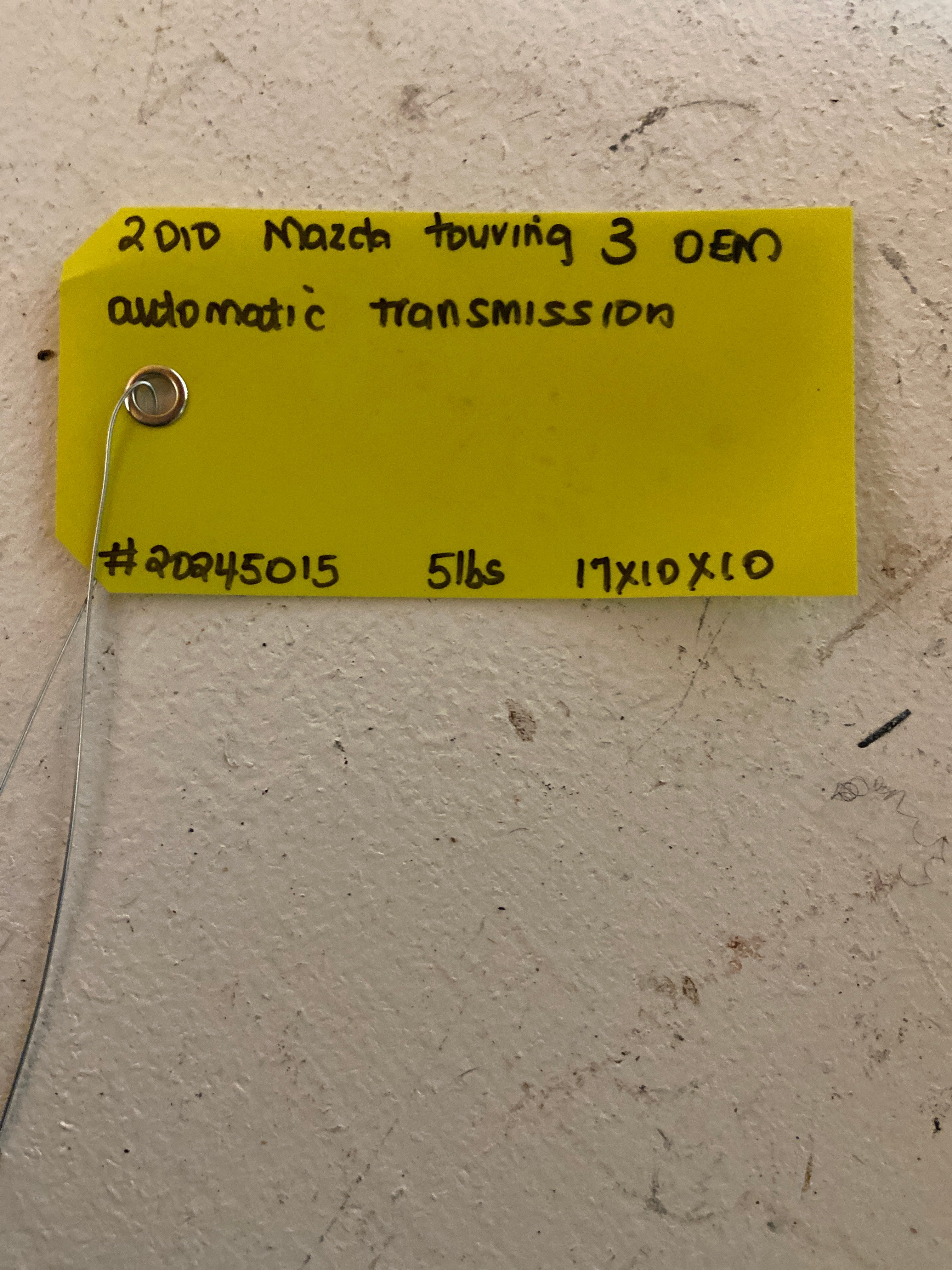 Yellow inventory tag with handwritten part number and weight details