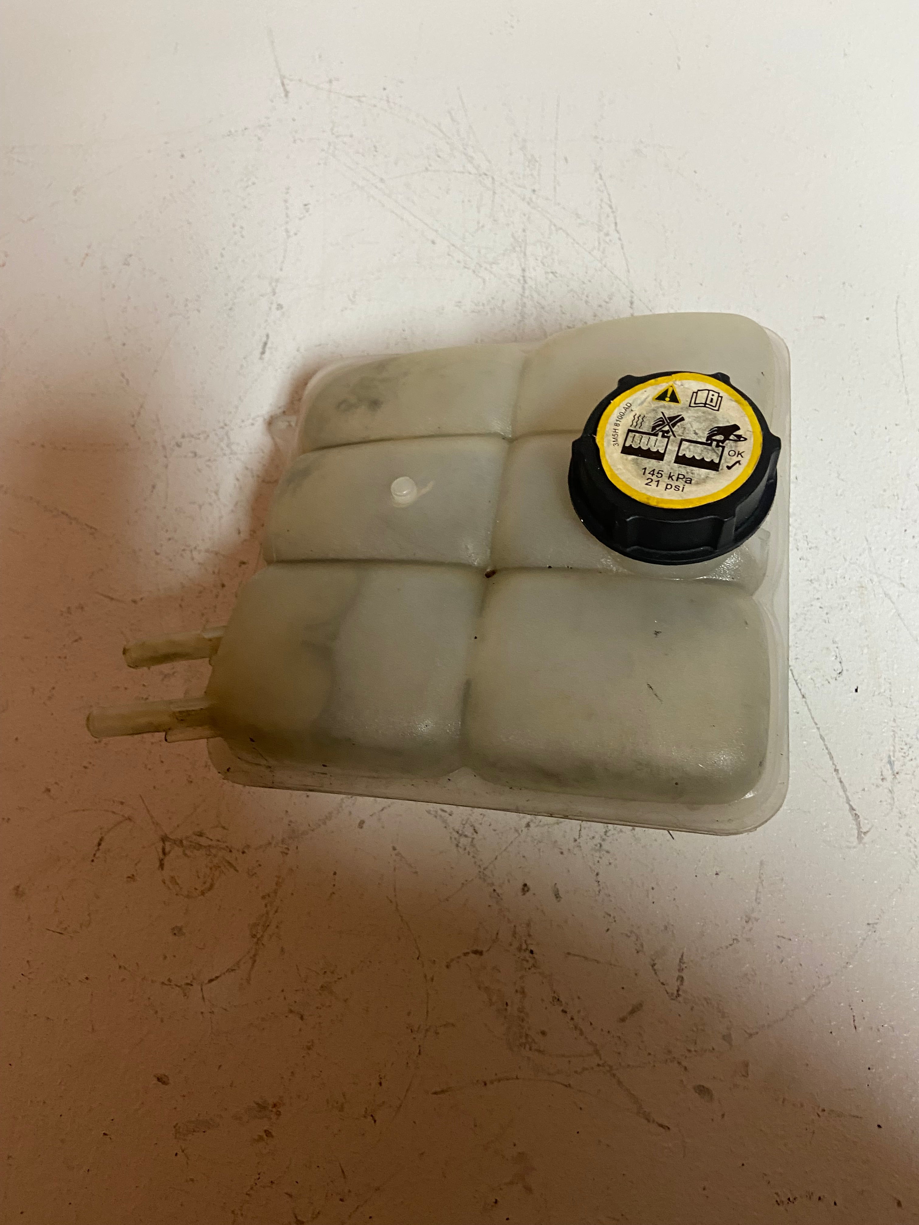 Engine coolant reservoir tank with black cap, translucent plastic