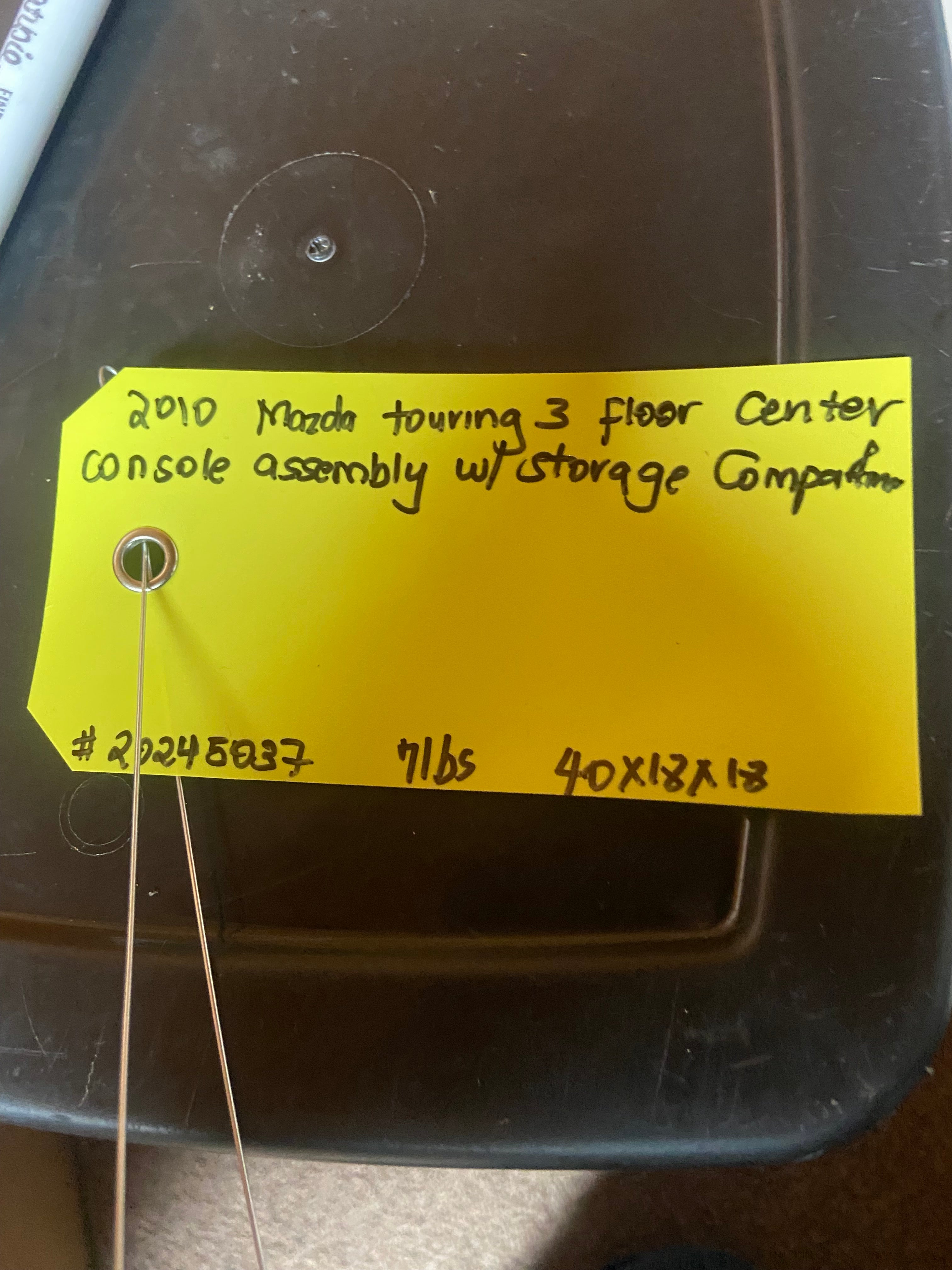 Black floor center console assembly with inventory label
