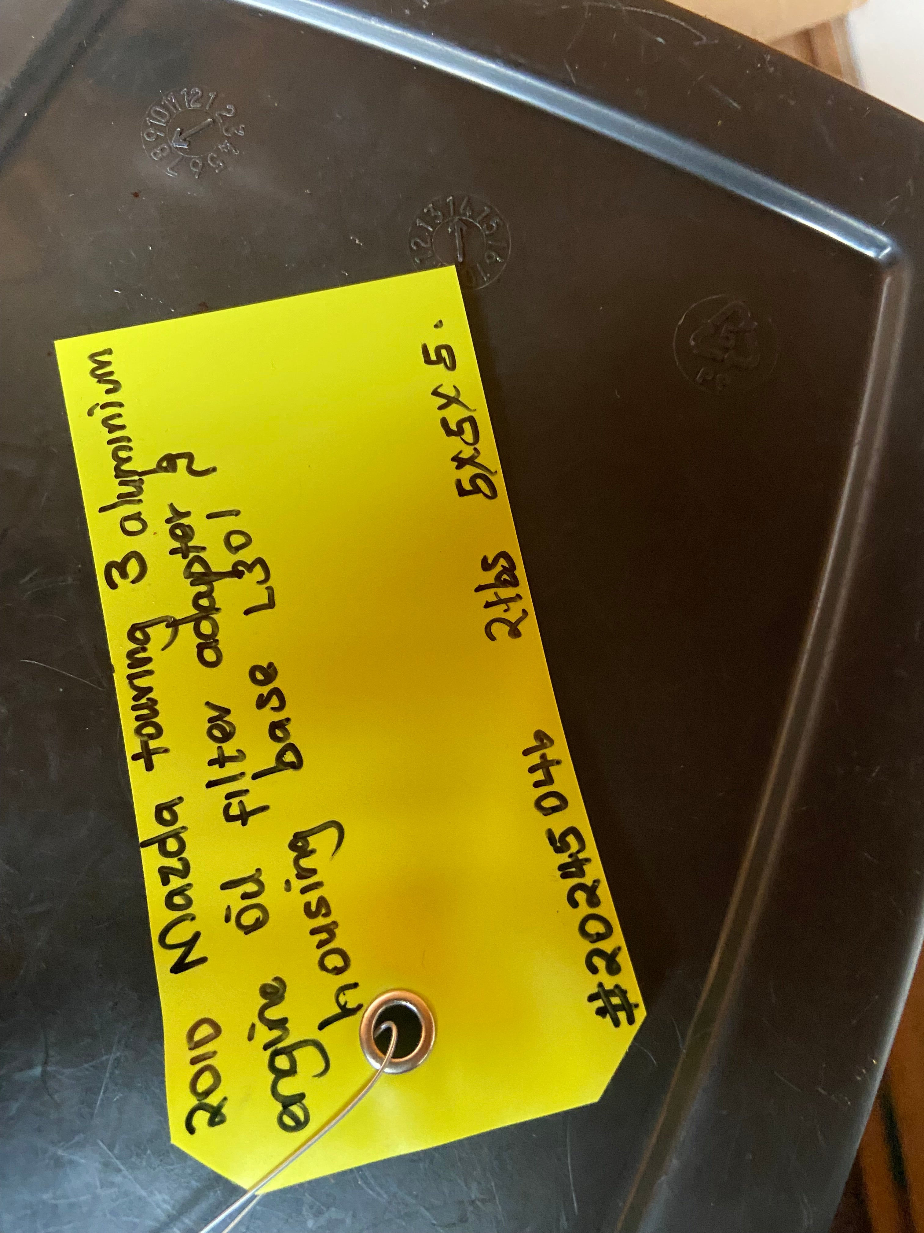 Metal engine oil filter adapter housing base with stamped markings