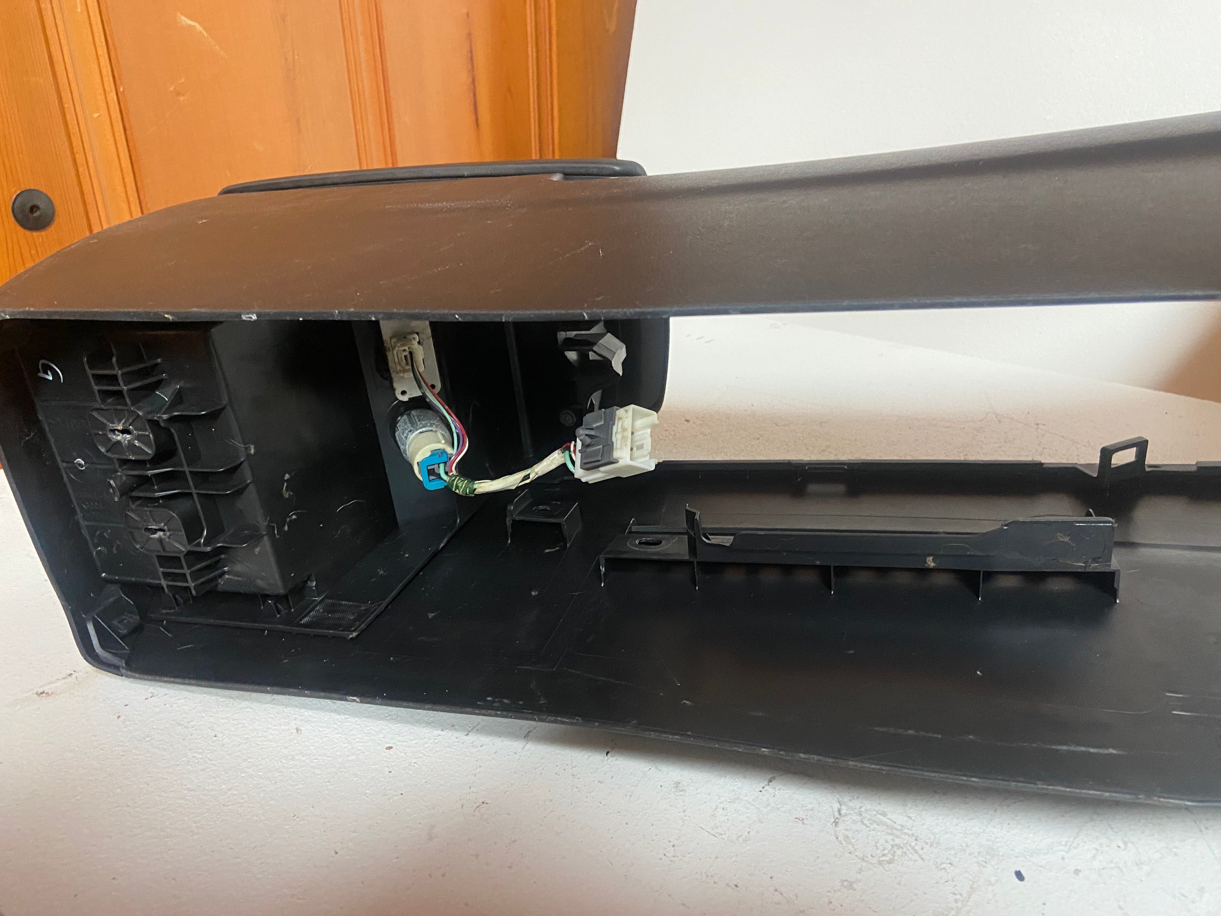 Black console housing with exposed wiring and retaining clips