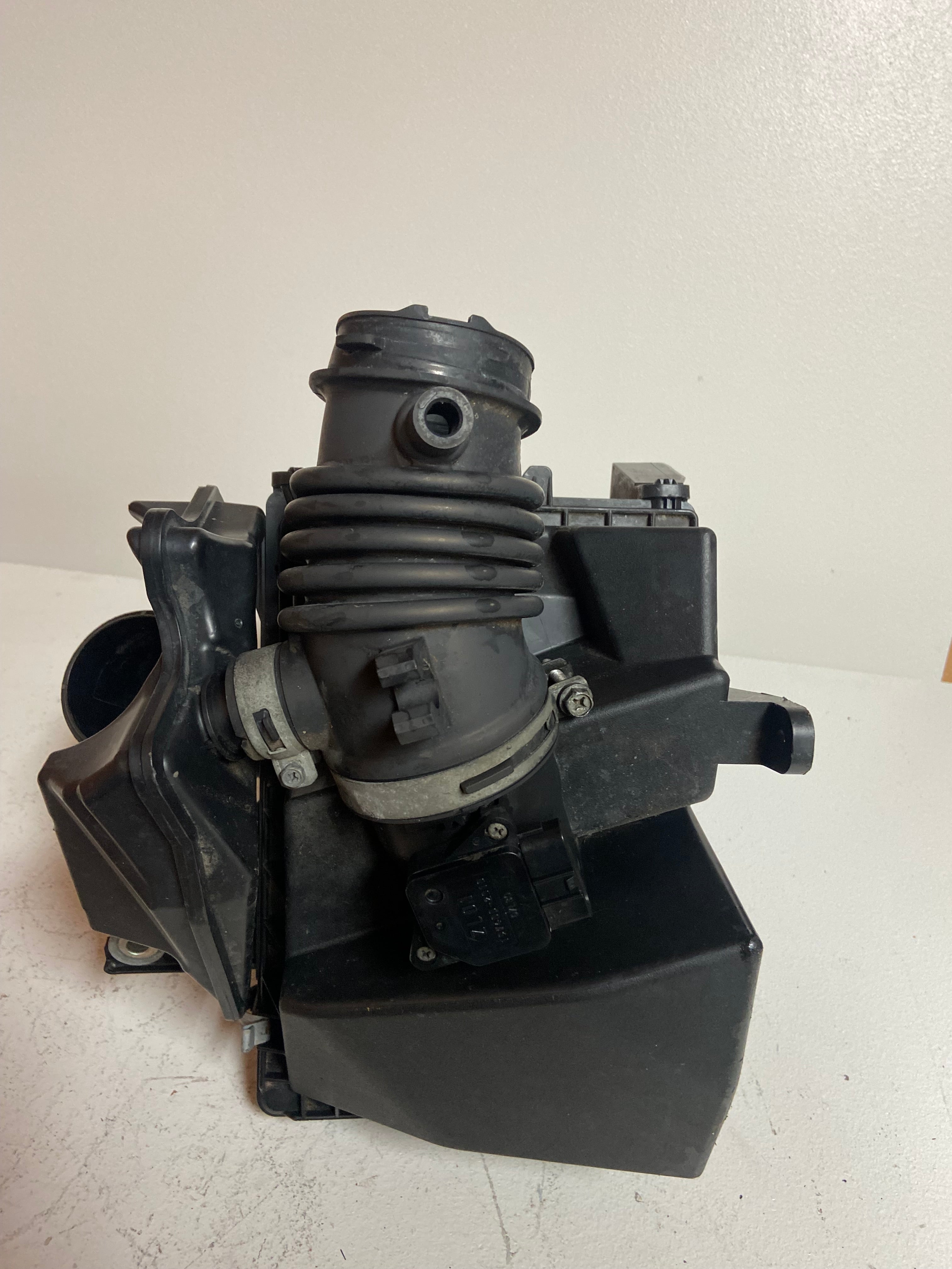 Air intake filter box housing with rubber intake tube and attached sensor area