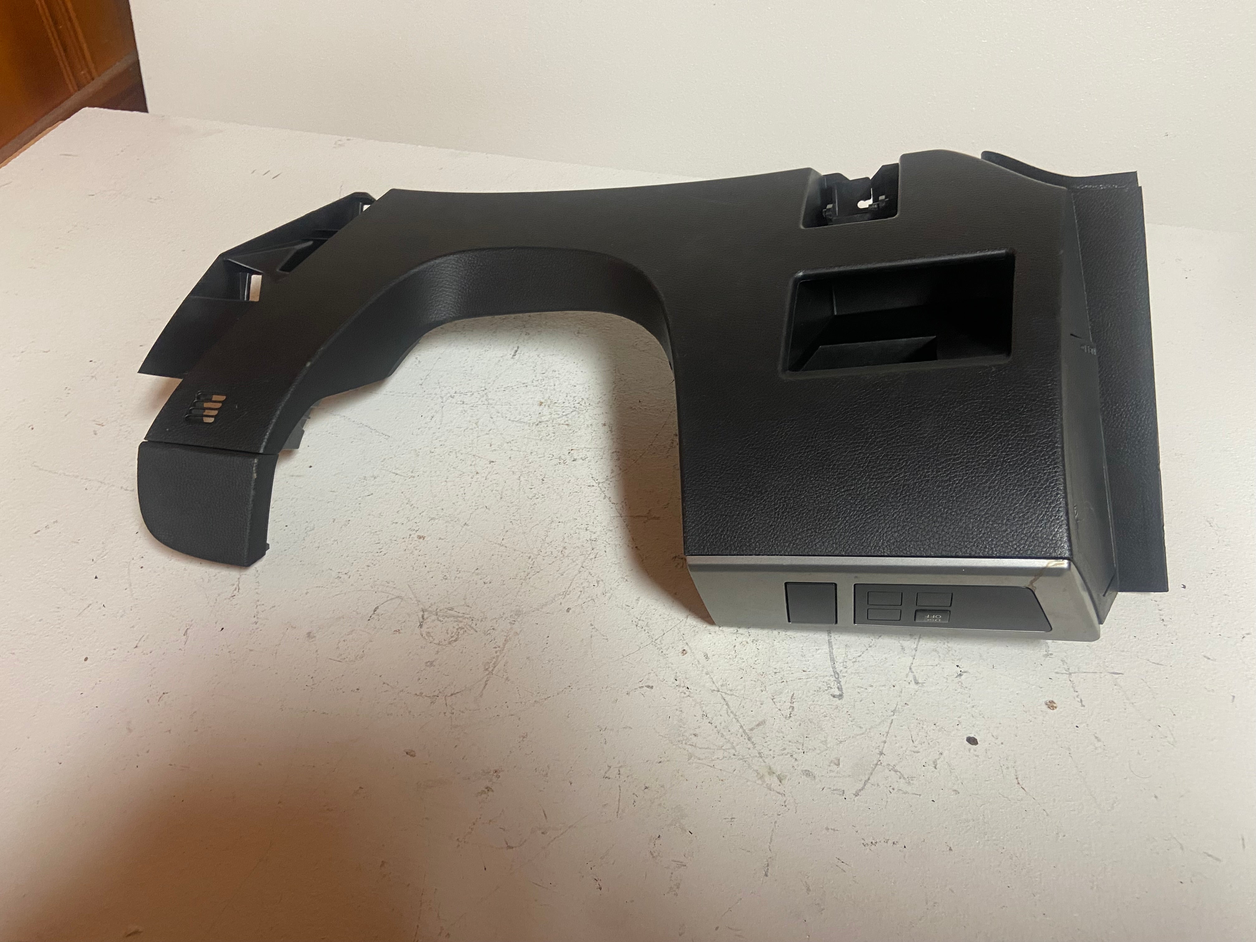 Black lower dash trim panel with curved edge and rectangular opening