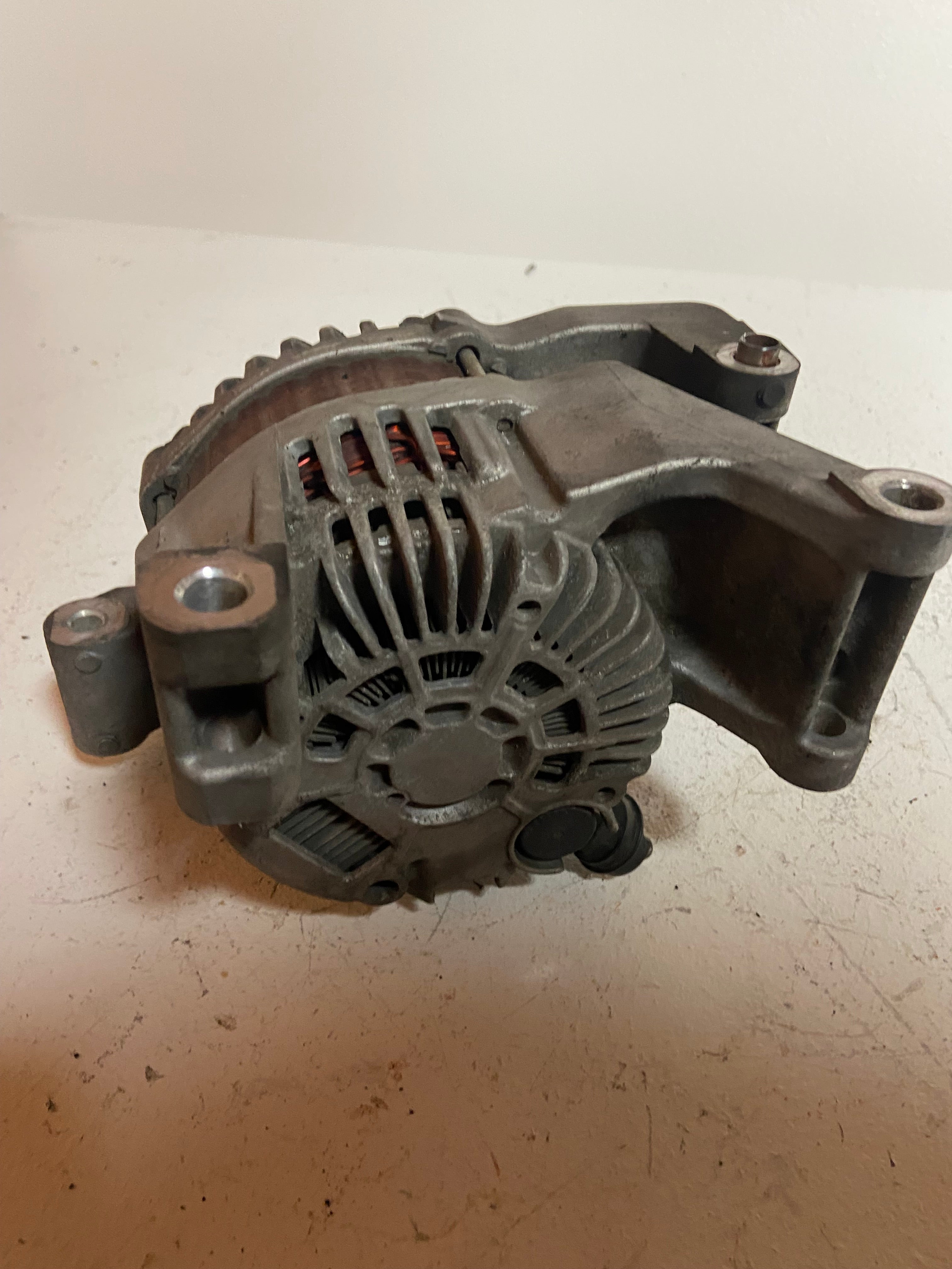 Gray alternator with vented fan, wiring plug, and mounting ears