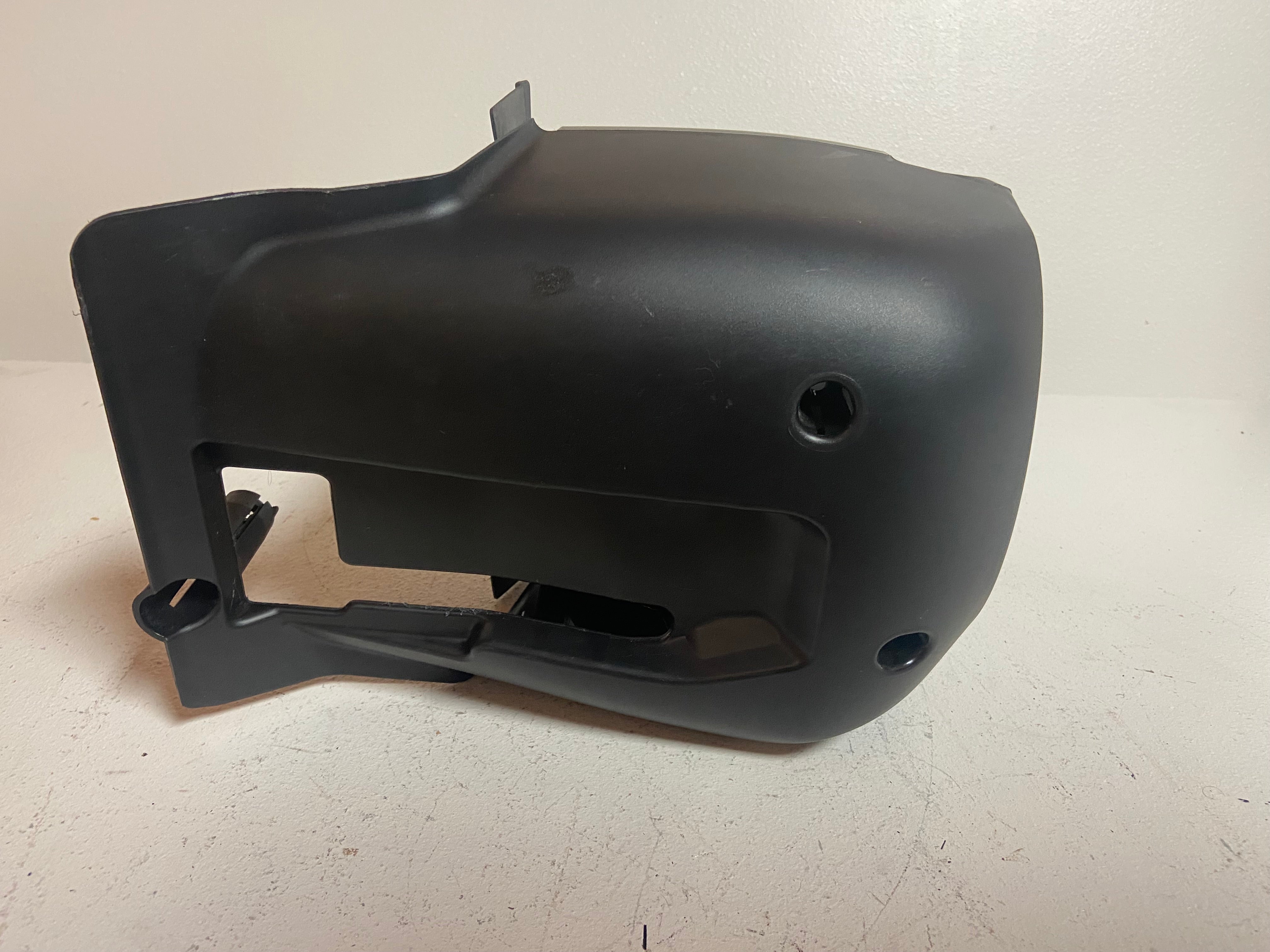 Black plastic steering column shroud cover with rectangular grille opening