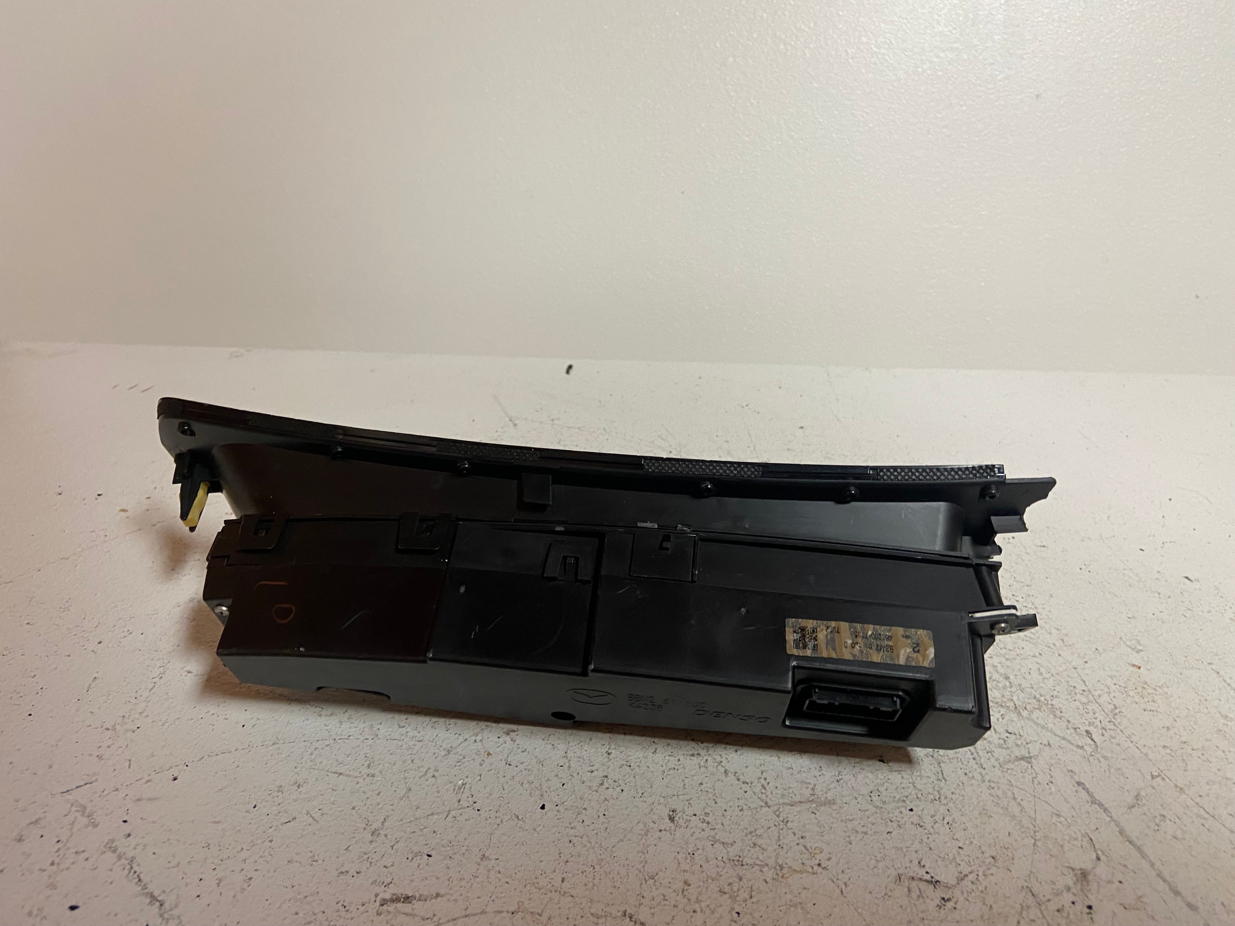 Black upper dash display screen bezel with cutouts and mounting tabs