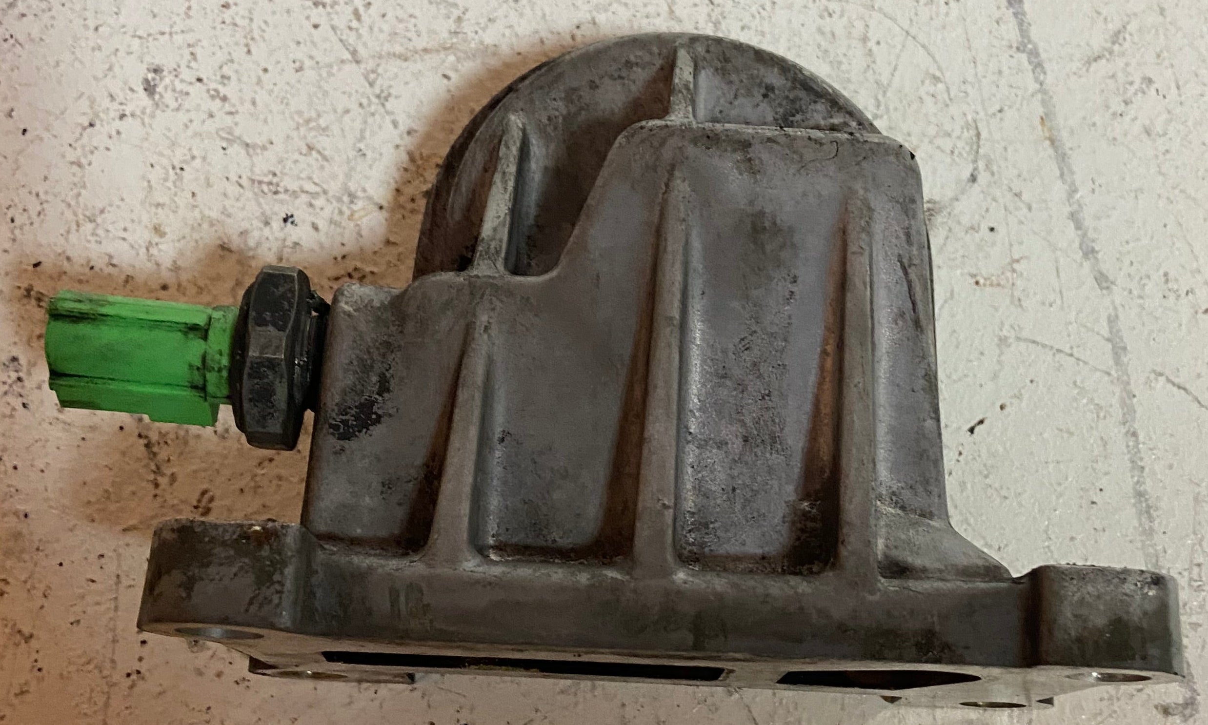 Metal engine oil filter adapter housing with green electrical connector plug