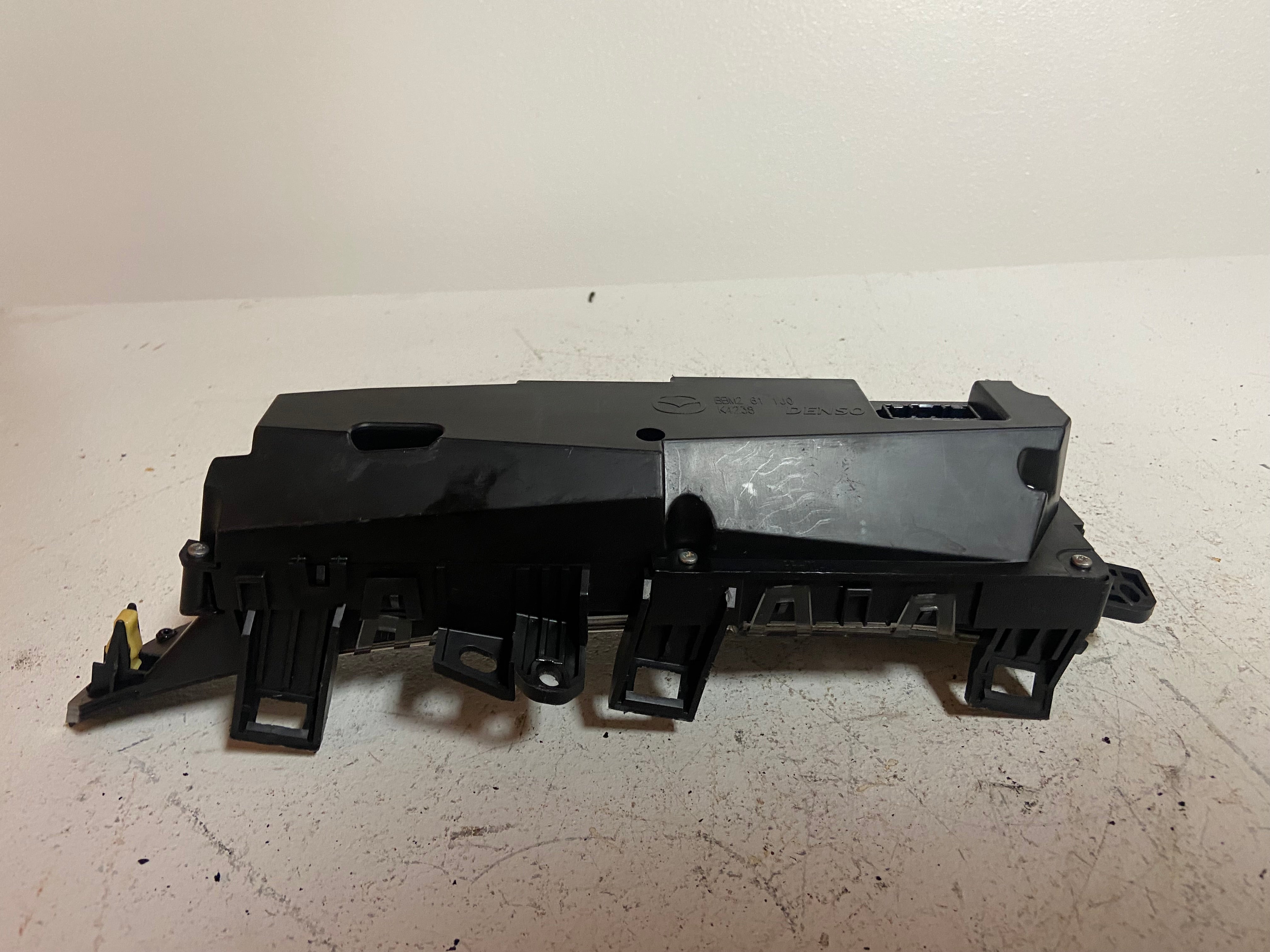 Black OEM upper dash display screen housing with mounting brackets and openings