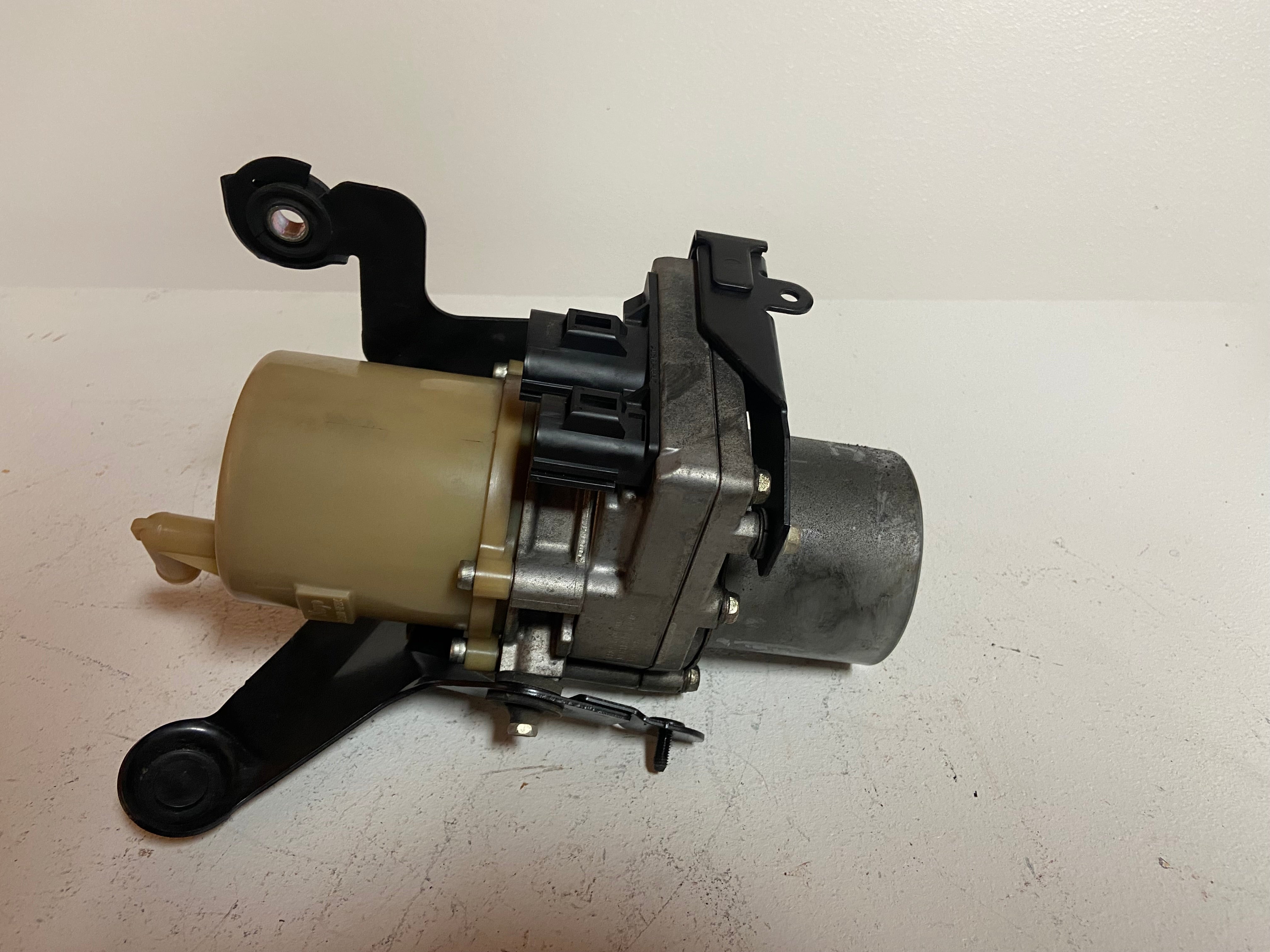 Power steering pump assembly with valve body and side electrical connector
