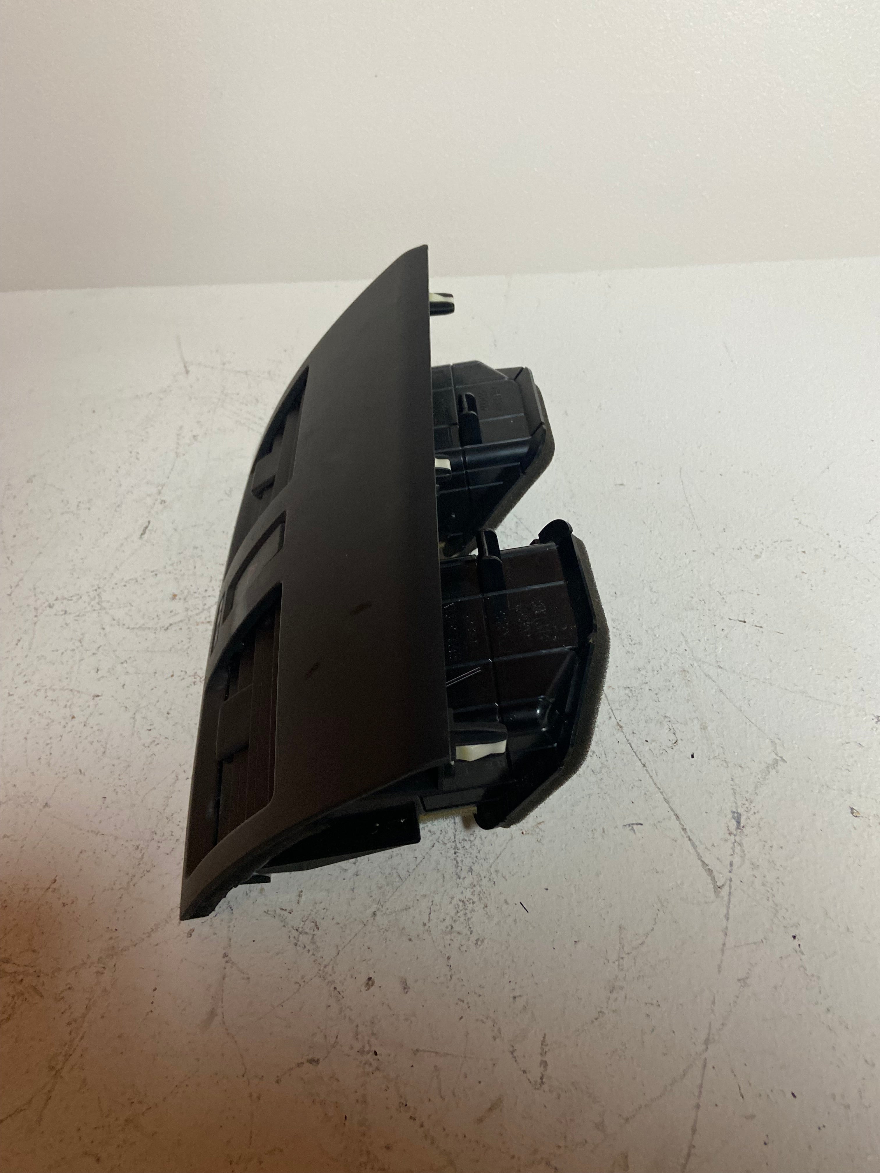 Black dashboard vent and hazard switch assembly, open housing with internal parts