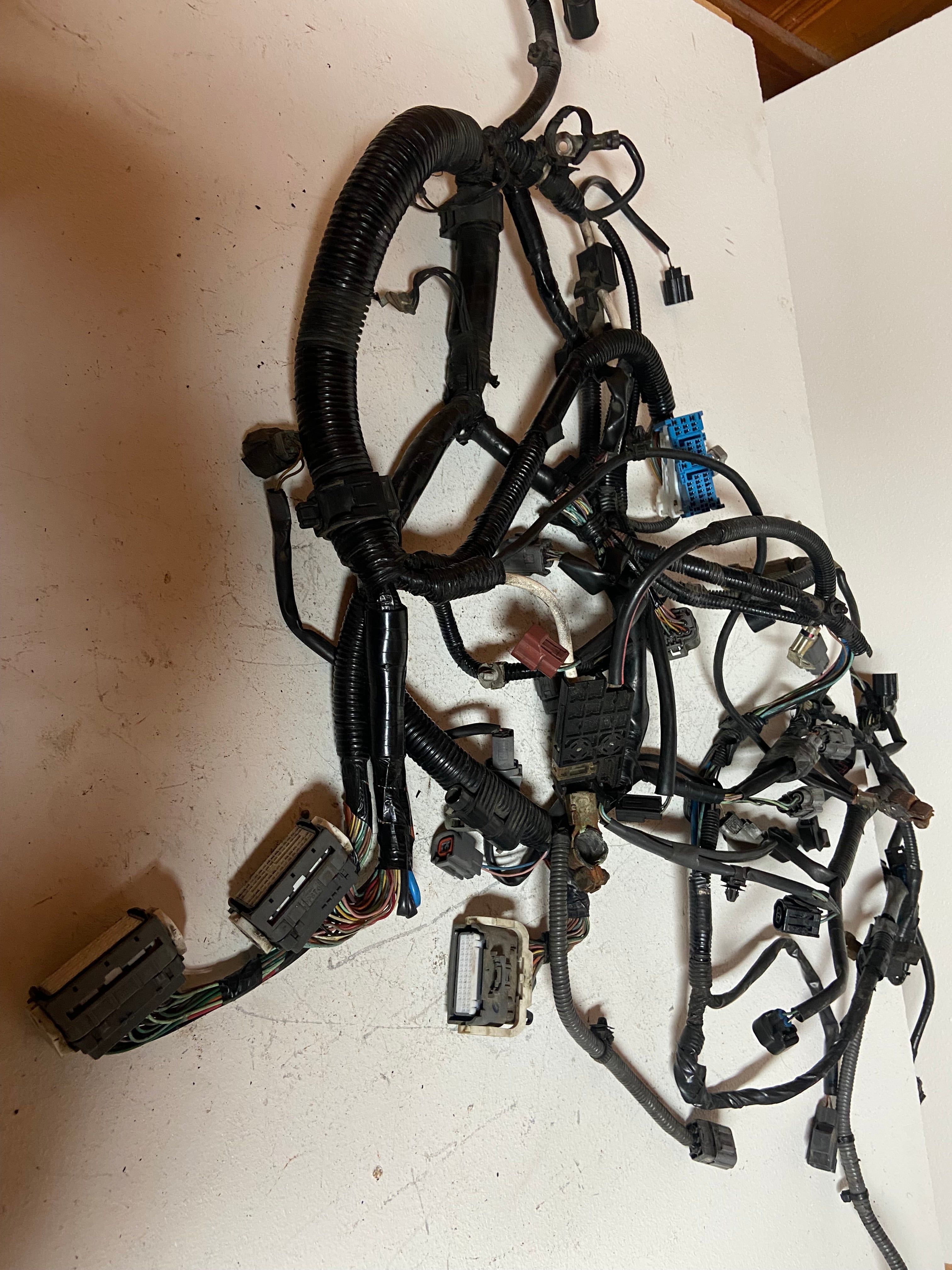 Engine wiring harness with bundled black cables, multiple plugs, and connector loom.