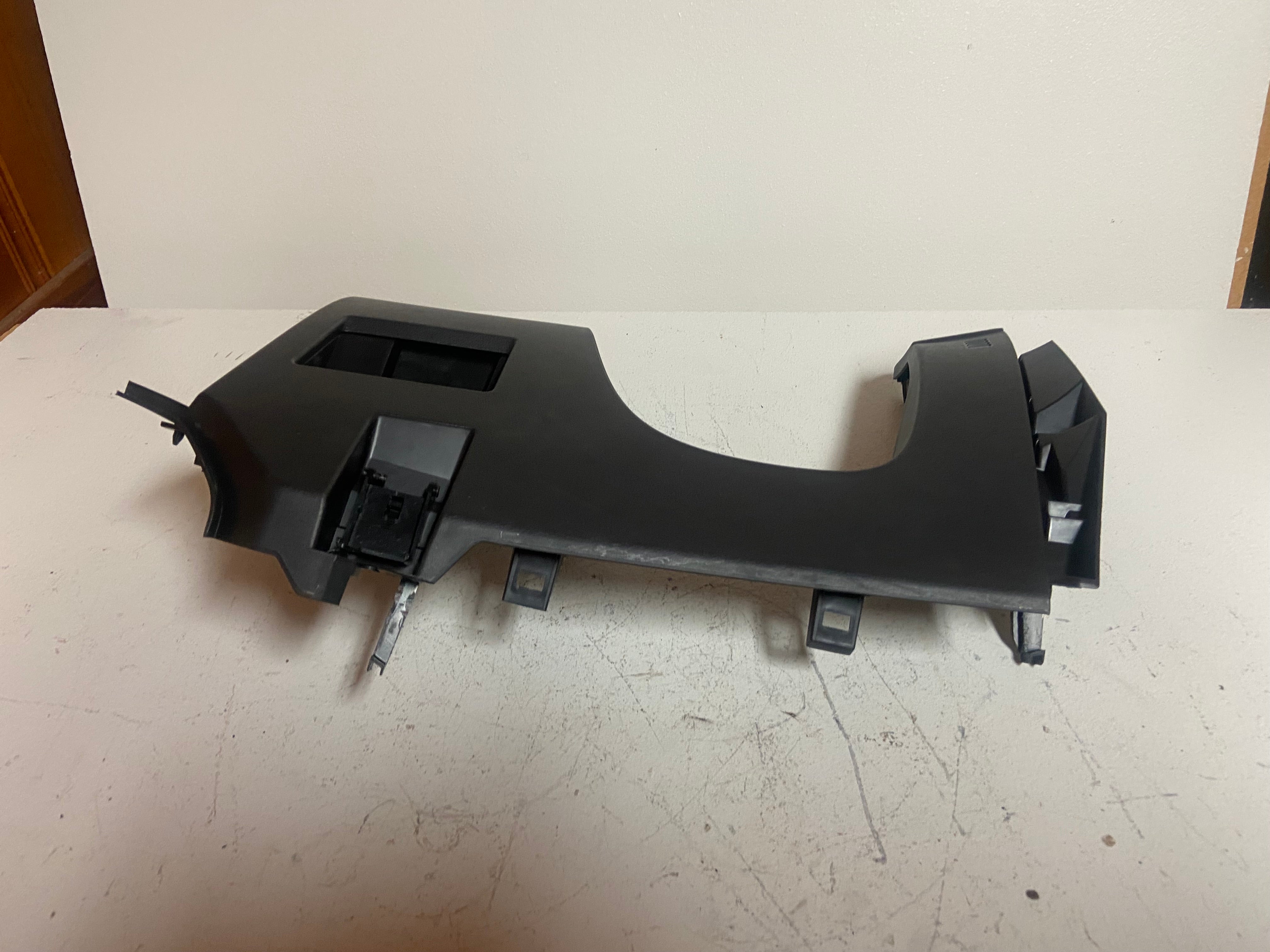 Black lower dash trim piece with rectangular vent openings