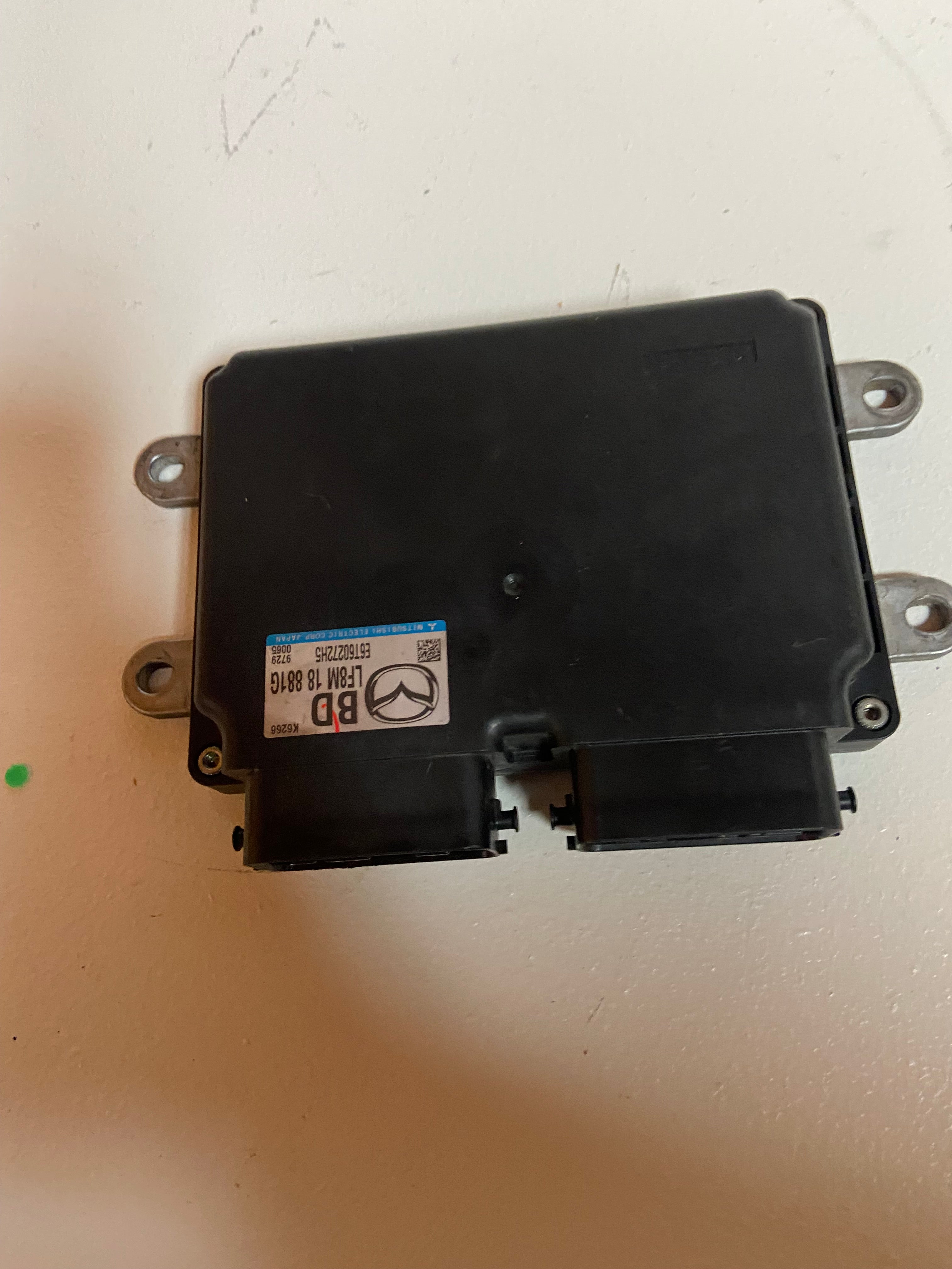 Black engine control unit with side connectors and attached identification label