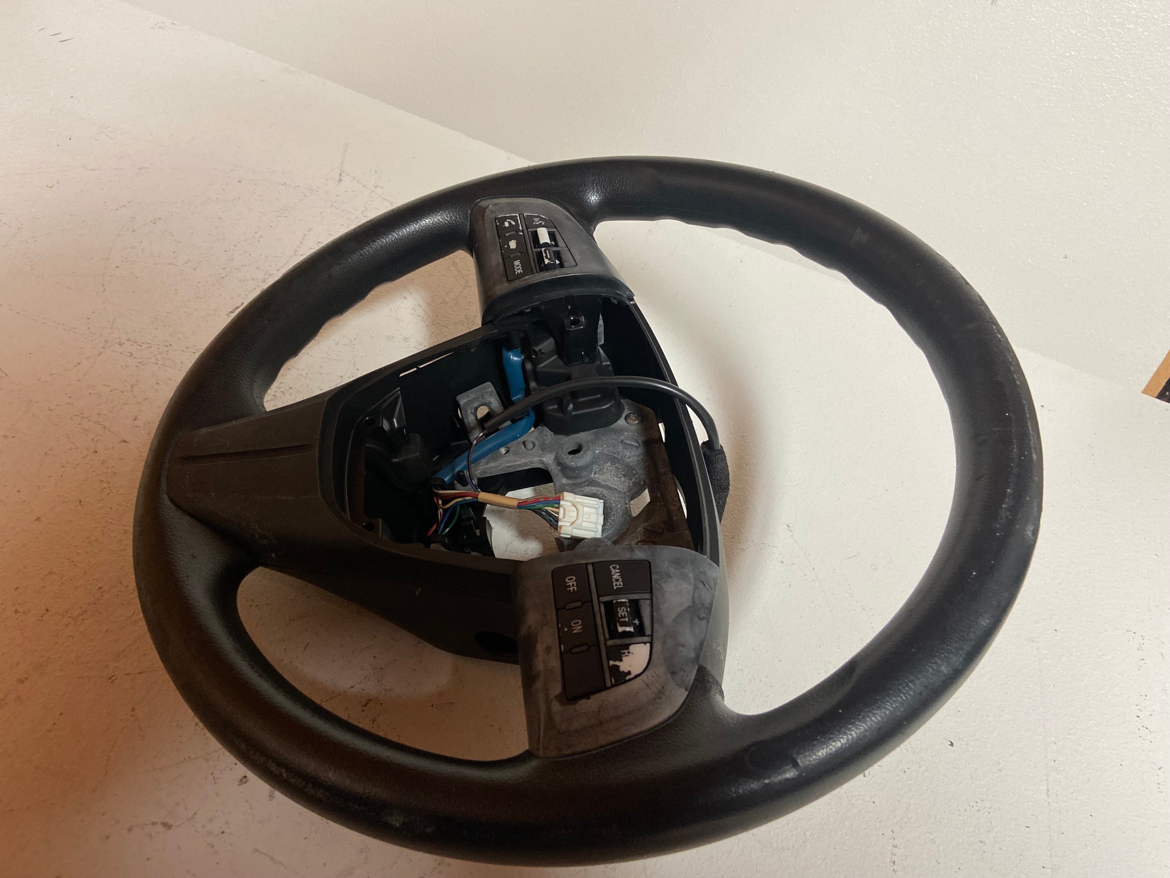 Black OEM steering wheel for 2010 Mazda 3 touring, rear view with wiring exposed
