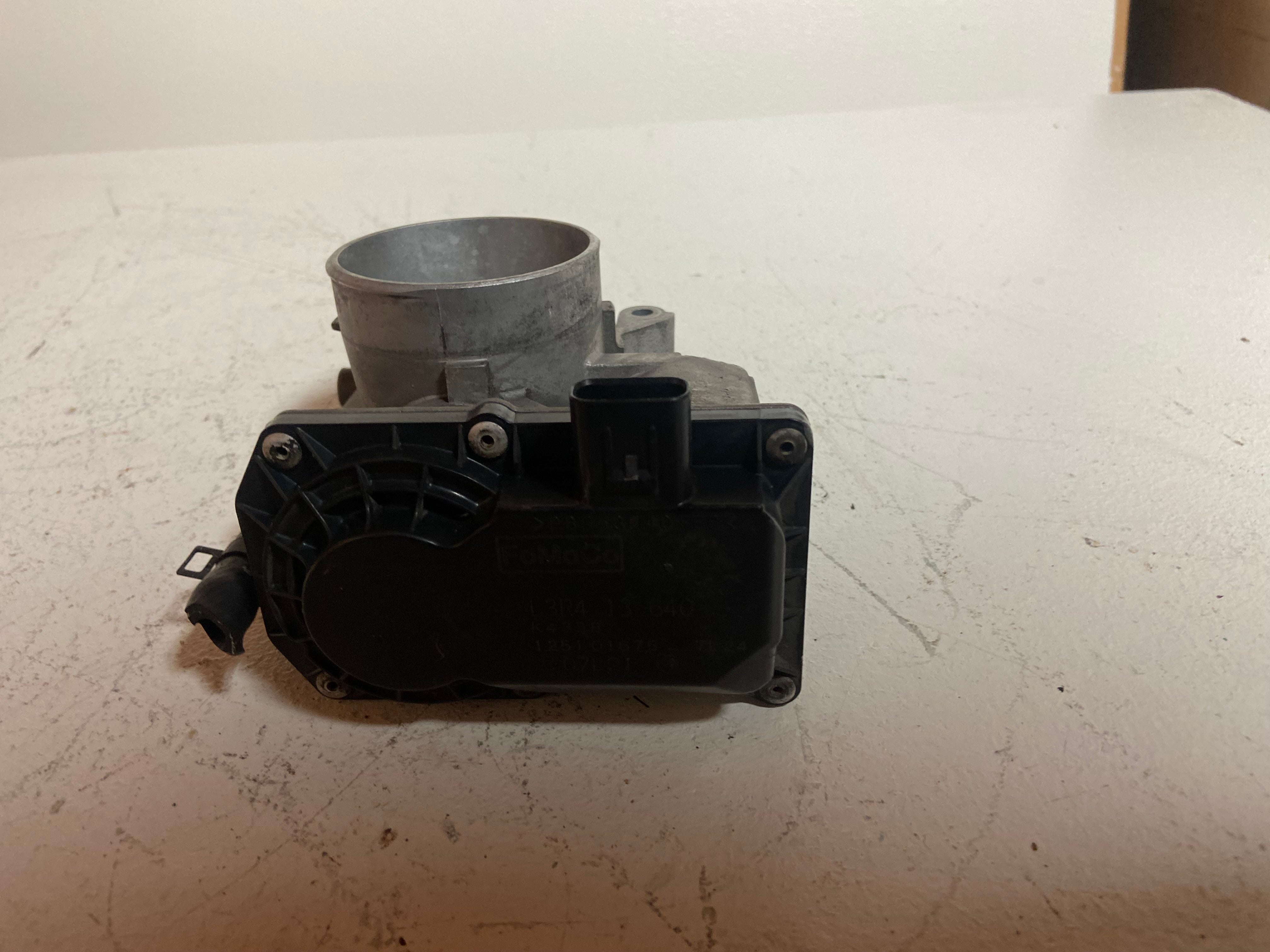 Throttle body with black plastic cover and metal intake bore