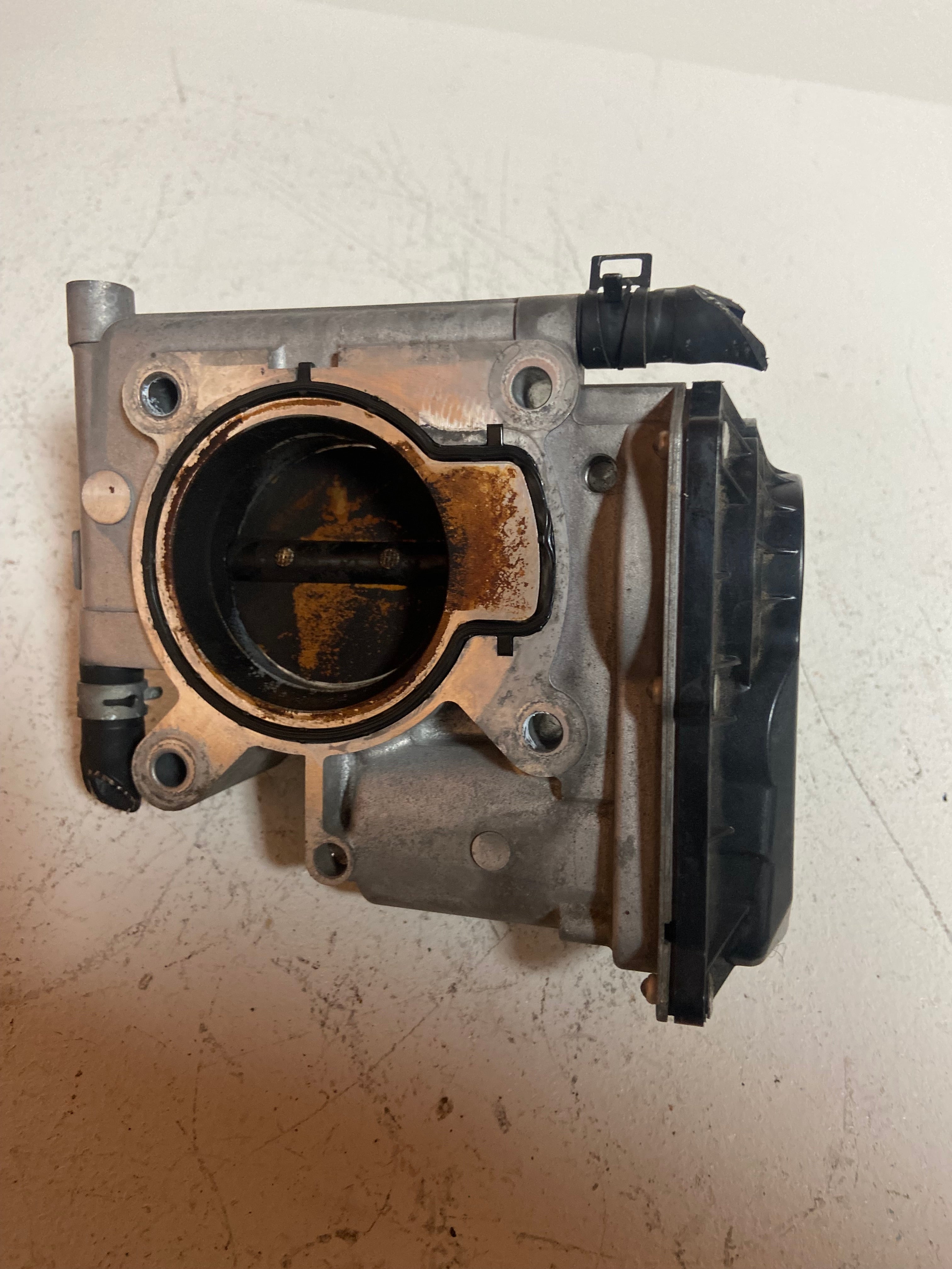 Throttle body assembly with round intake bore and black sensor connector