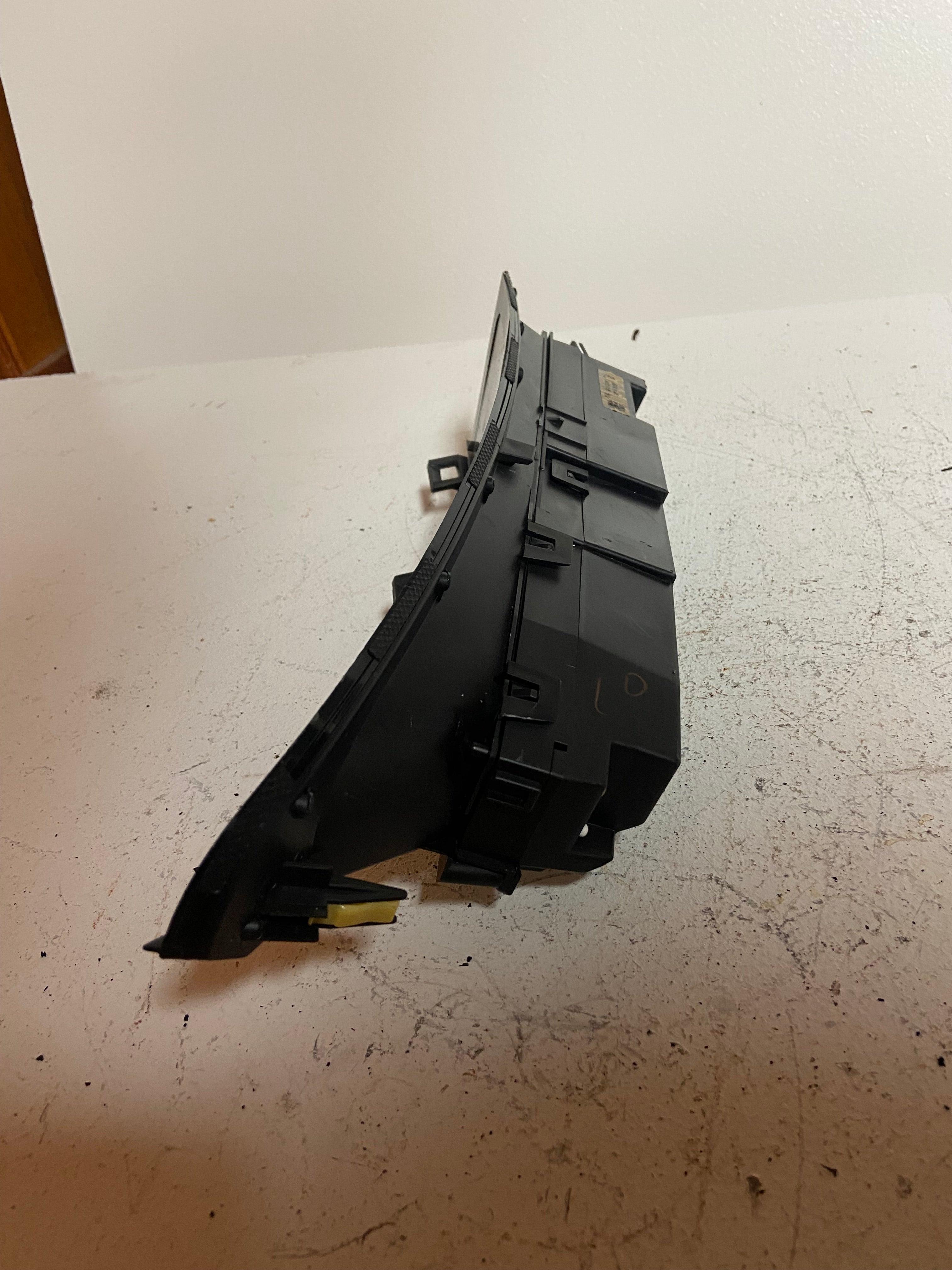 Black dashboard display screen module, angled view showing mounting rail clips