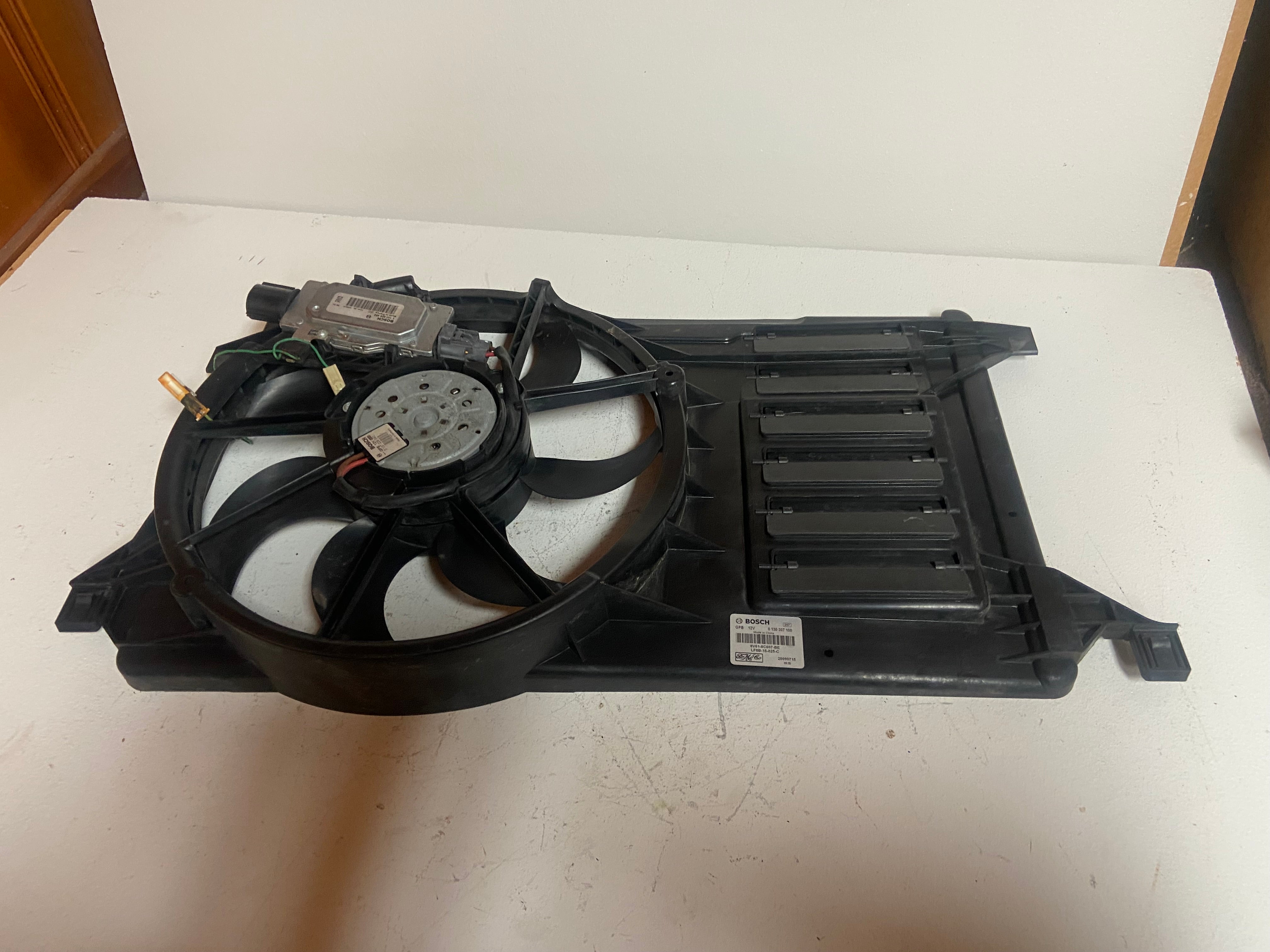 Electric radiator cooling fan assembly with shroud, fan, and grille housing