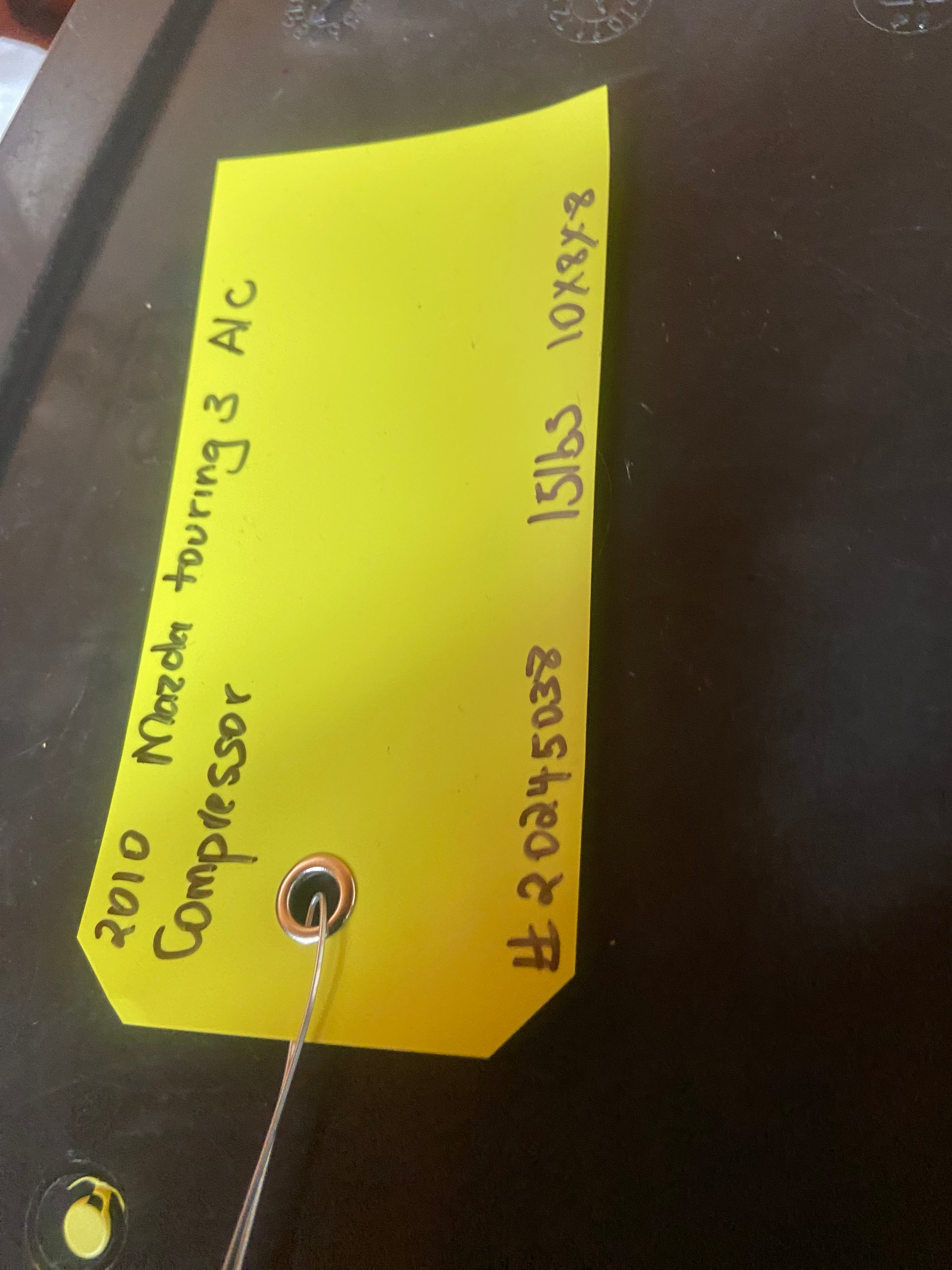 A/C compressor core with yellow inventory label and wire leads