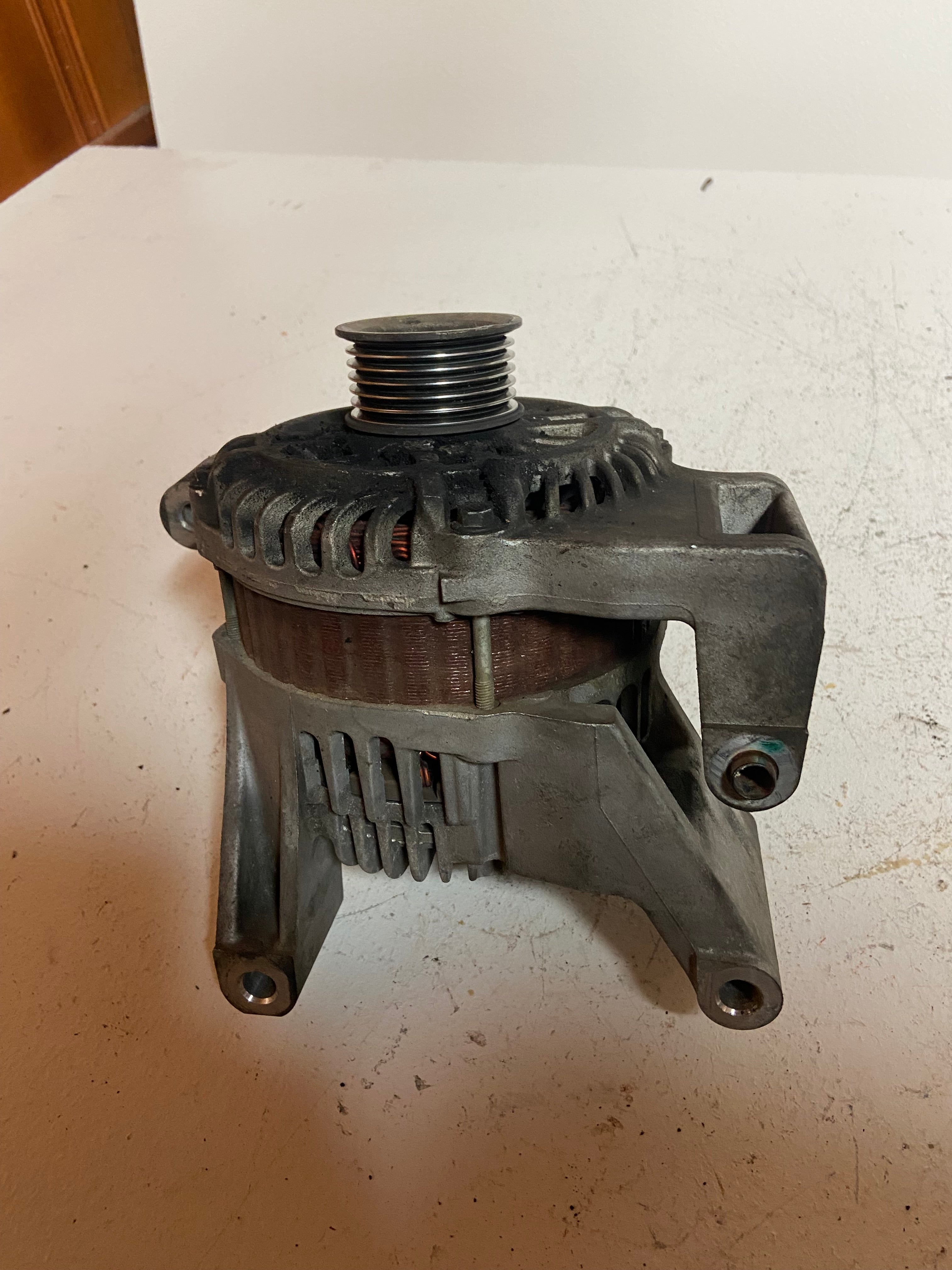Gray alternator with top pulley and side mounting feet